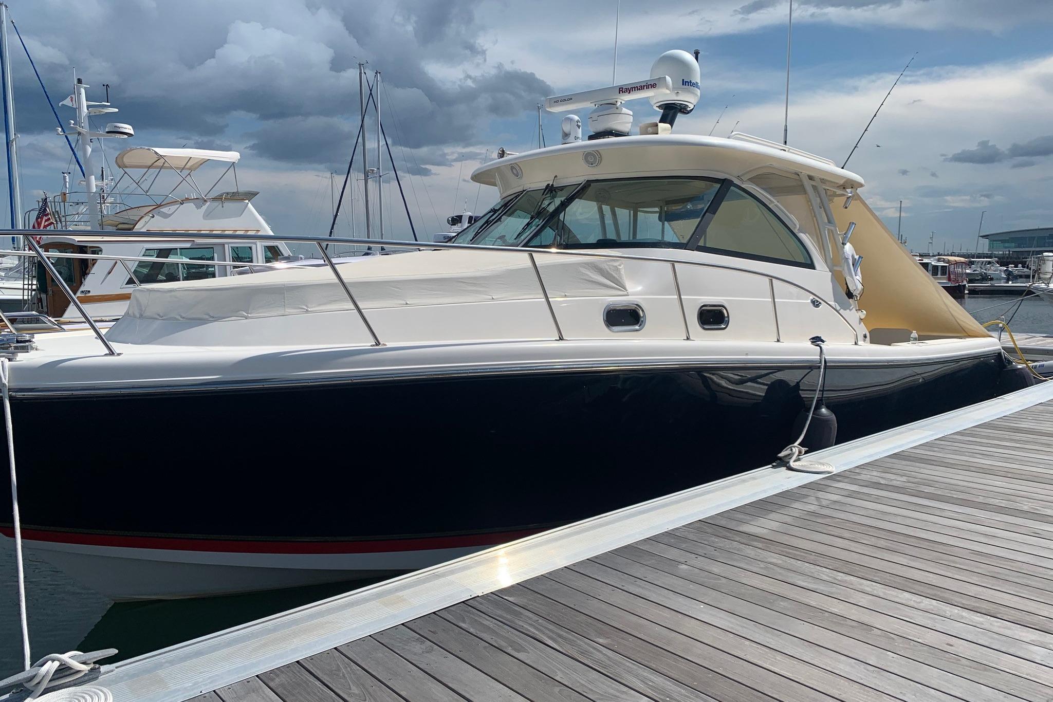 2009 Pursuit OS 375 Offshore boat docked at marina under cloudy sky.