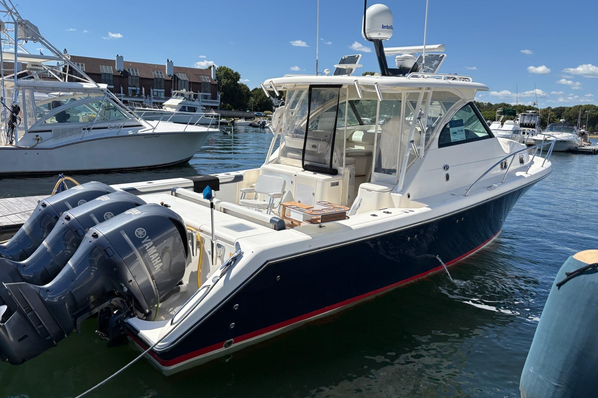 2009 Pursuit OS 375 Offshore boat docked with triple Yamaha engines.