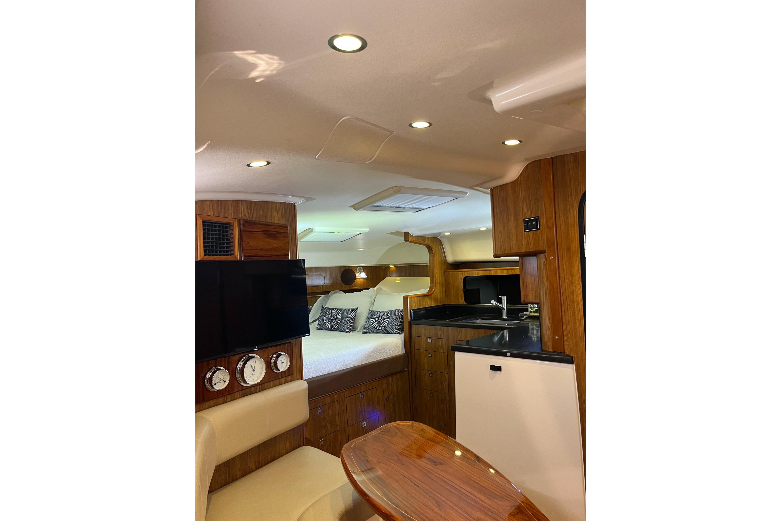 Luxurious interior of 2009 Pursuit OS 375 Offshore boat with cozy bed and modern amenities.