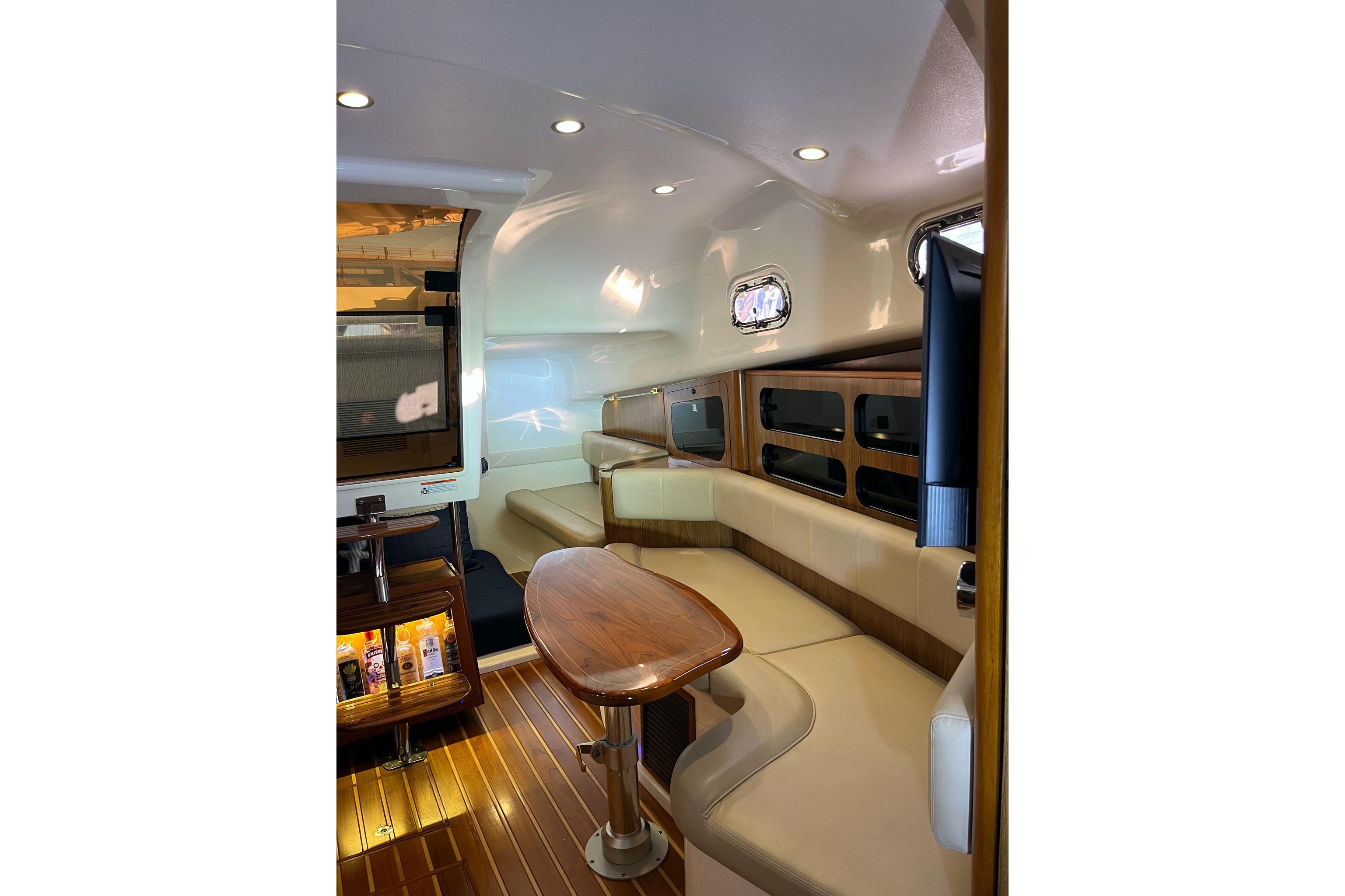 Luxurious interior of 2009 Pursuit OS 375 Offshore boat with elegant seating and wooden accents.