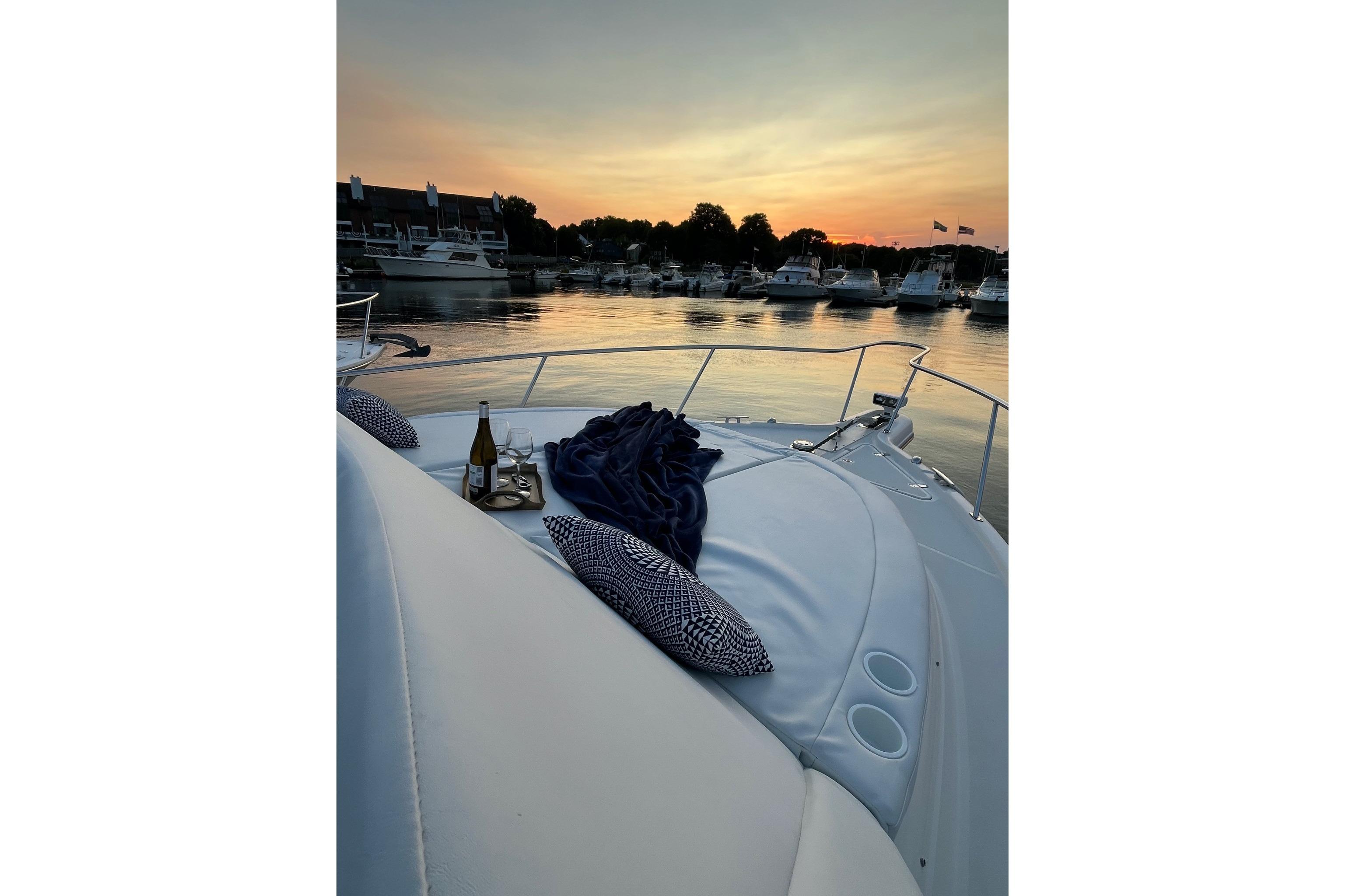 2009 Pursuit OS 375 Offshore yacht at sunset with wine and pillows on deck.