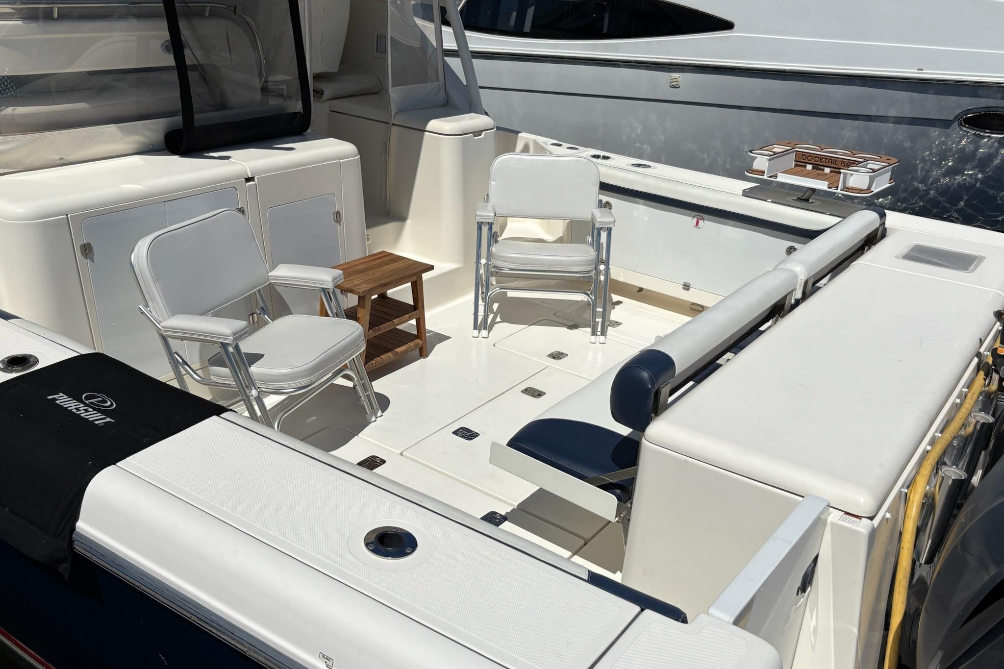2009 Pursuit OS 375 Offshore boat deck with chairs and table, showcasing spacious seating area.
