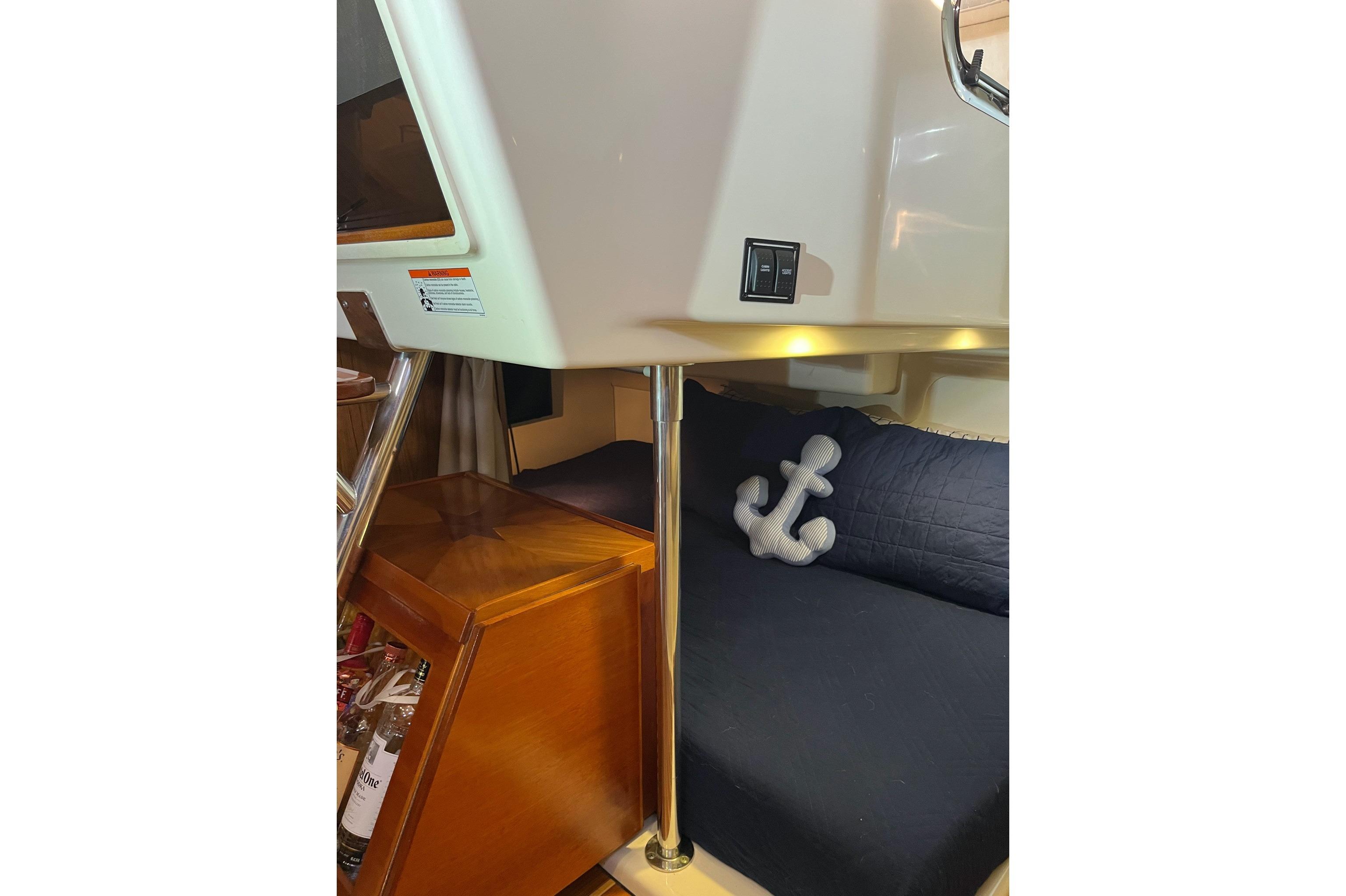 2009 Pursuit OS 375 Offshore cabin interior with anchor pillow and wooden cabinet.