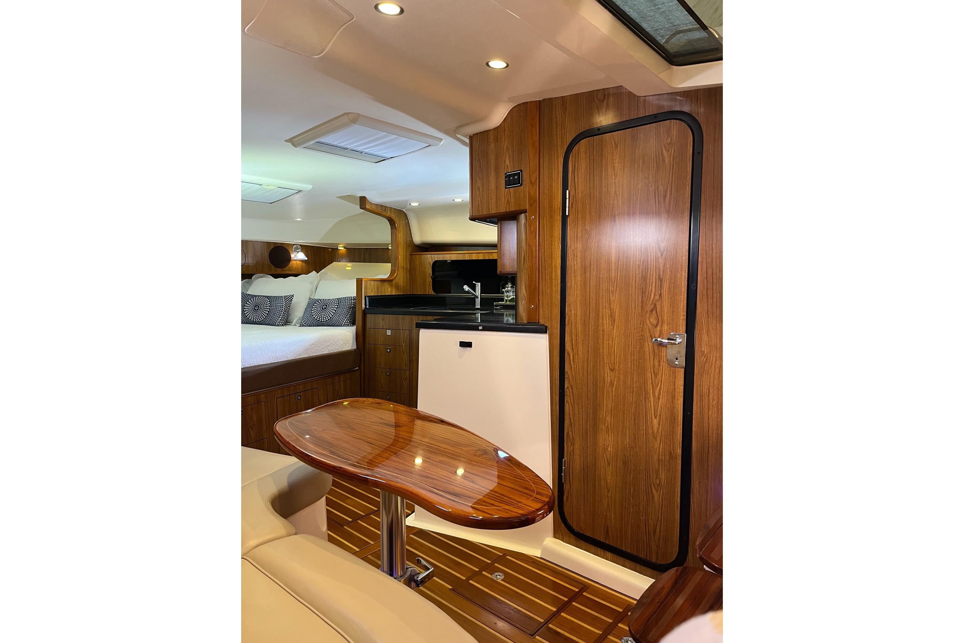 Luxurious interior of 2009 Pursuit OS 375 Offshore boat with wood finishes and cozy seating.