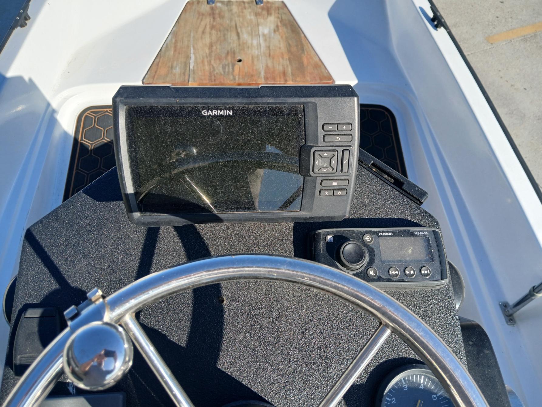 1980 Boston Whaler 15 Montauk dashboard with Garmin navigation system and steering wheel.
