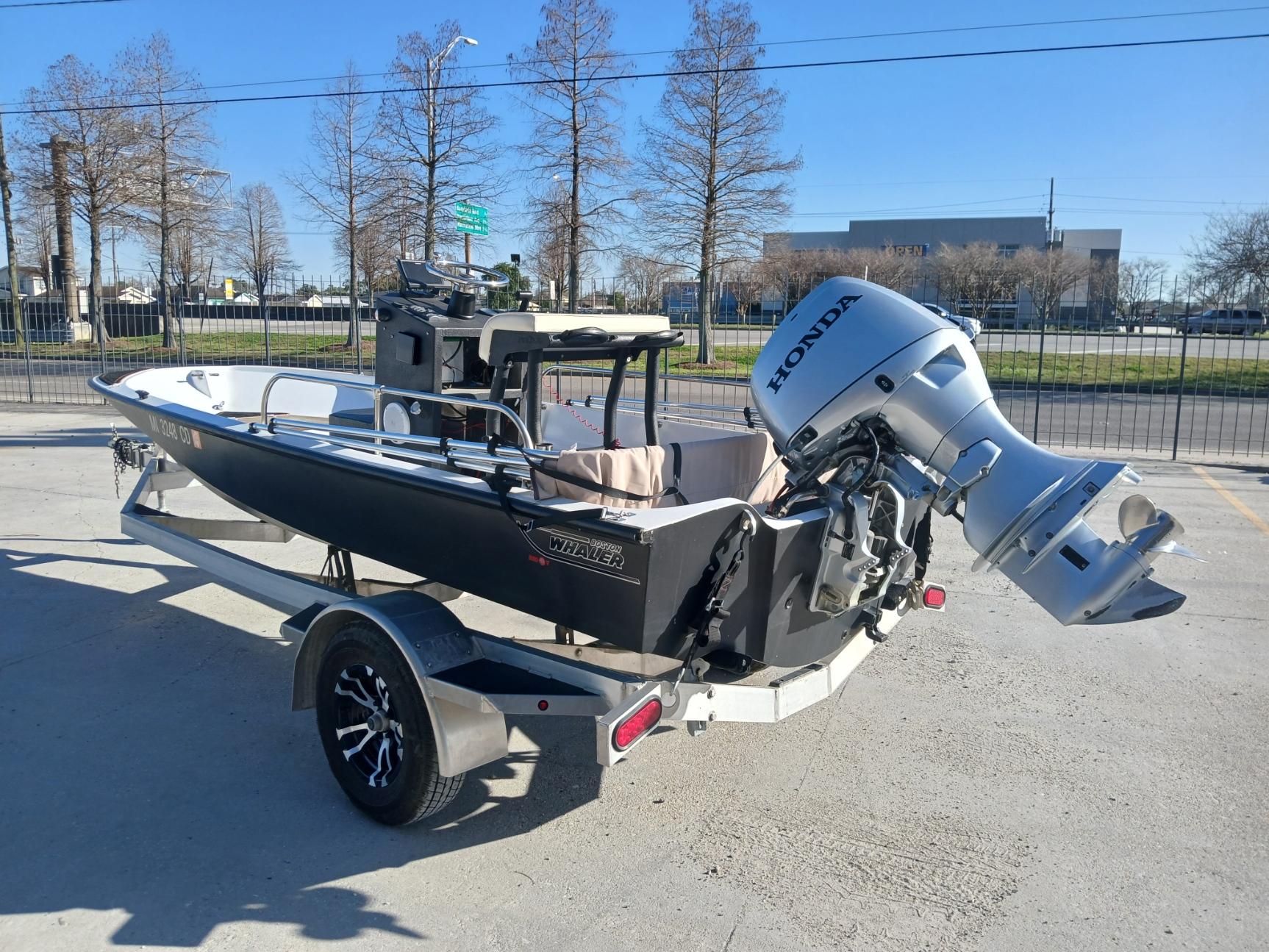 1980 Boston Whaler 15 Montauk boat with Honda outboard motor on a trailer.
