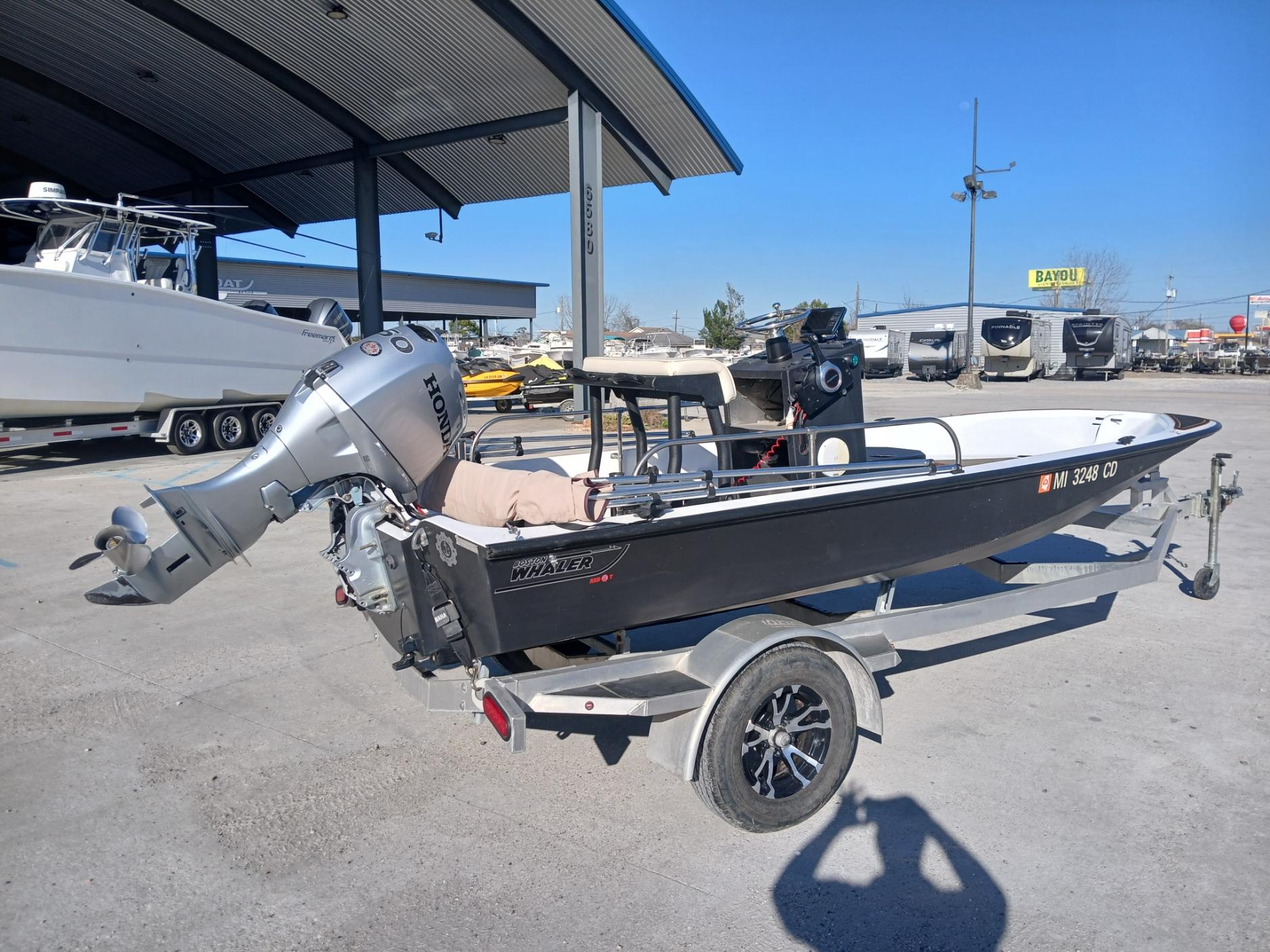 1980 Boston Whaler 15 Montauk boat on trailer, parked outdoors under a canopy.
