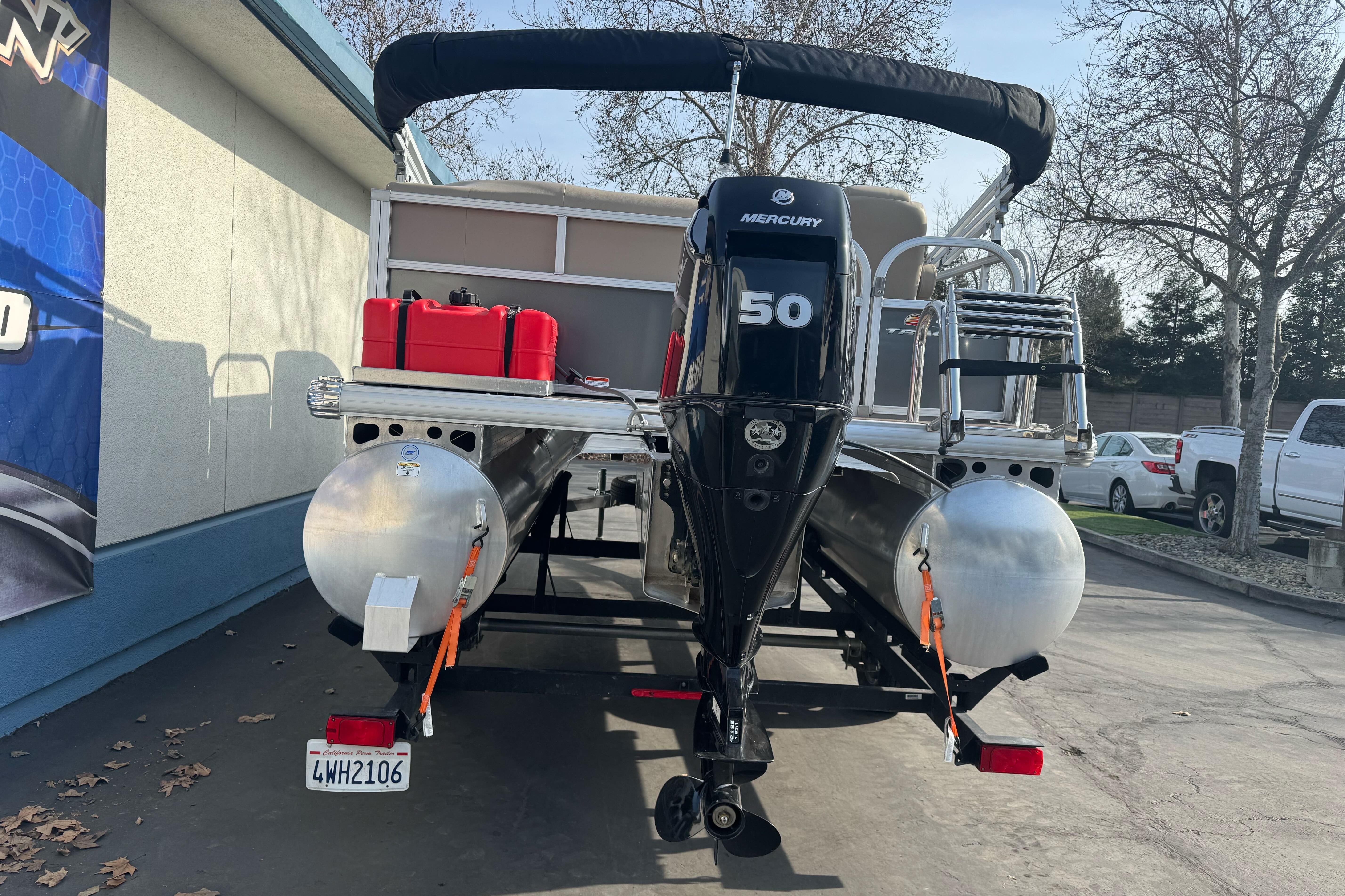 2024 Sun Tracker Party Barge 16 DLX with Mercury 50 engine, parked outdoors.