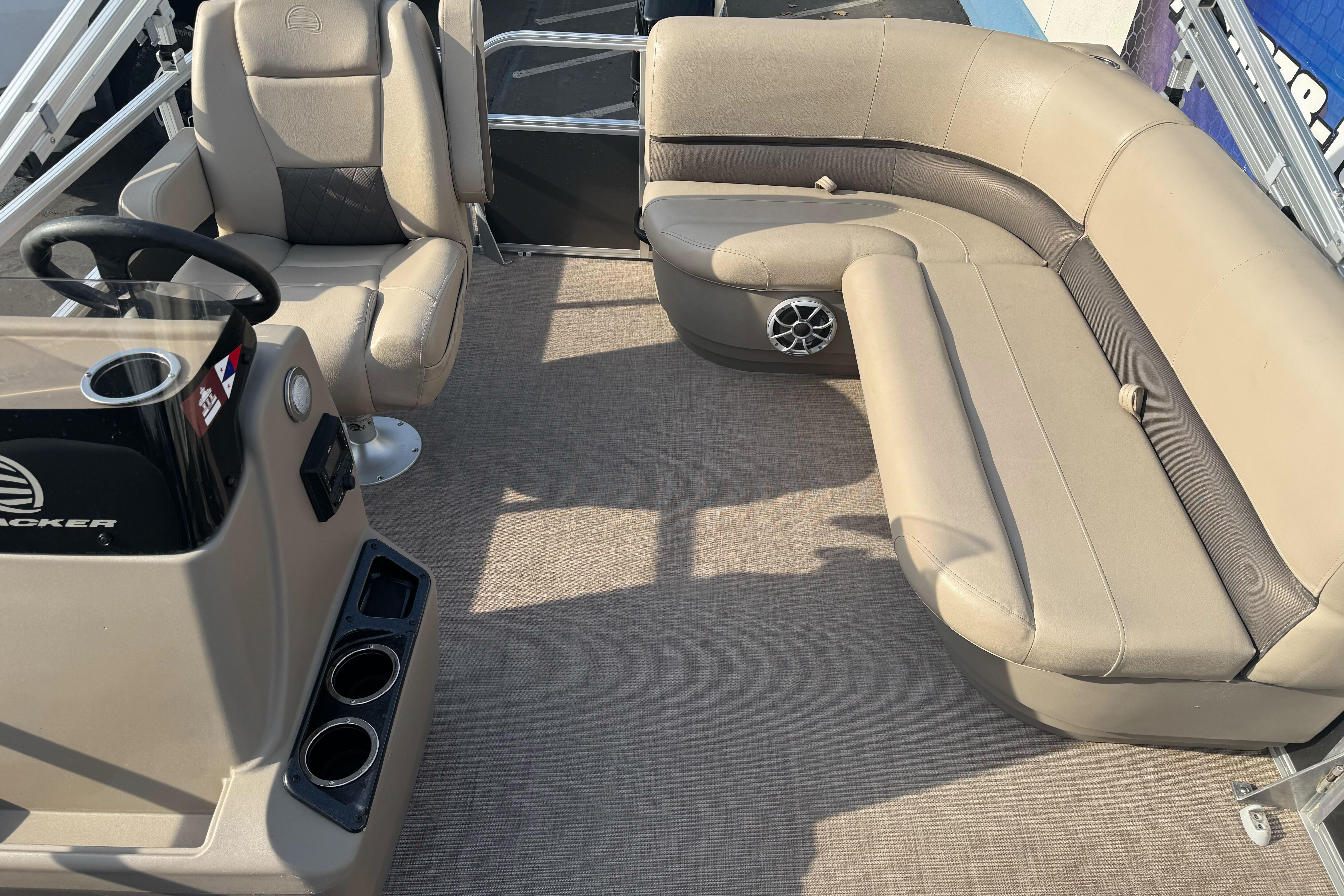 2024 Sun Tracker Party Barge 16 DLX interior with beige seating and steering console.