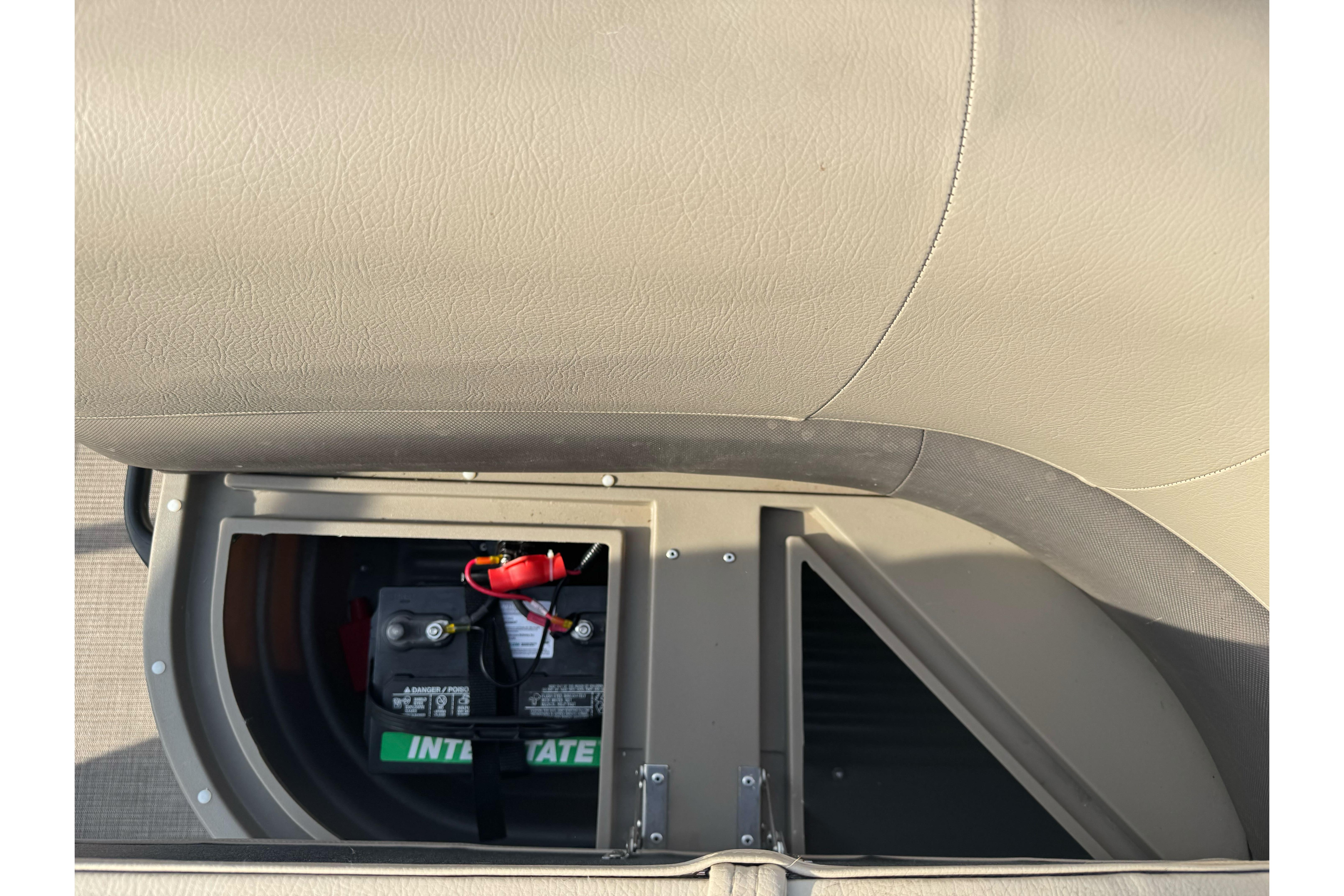 2024 Sun Tracker Party Barge 16 DLX battery compartment with visible battery and wiring.