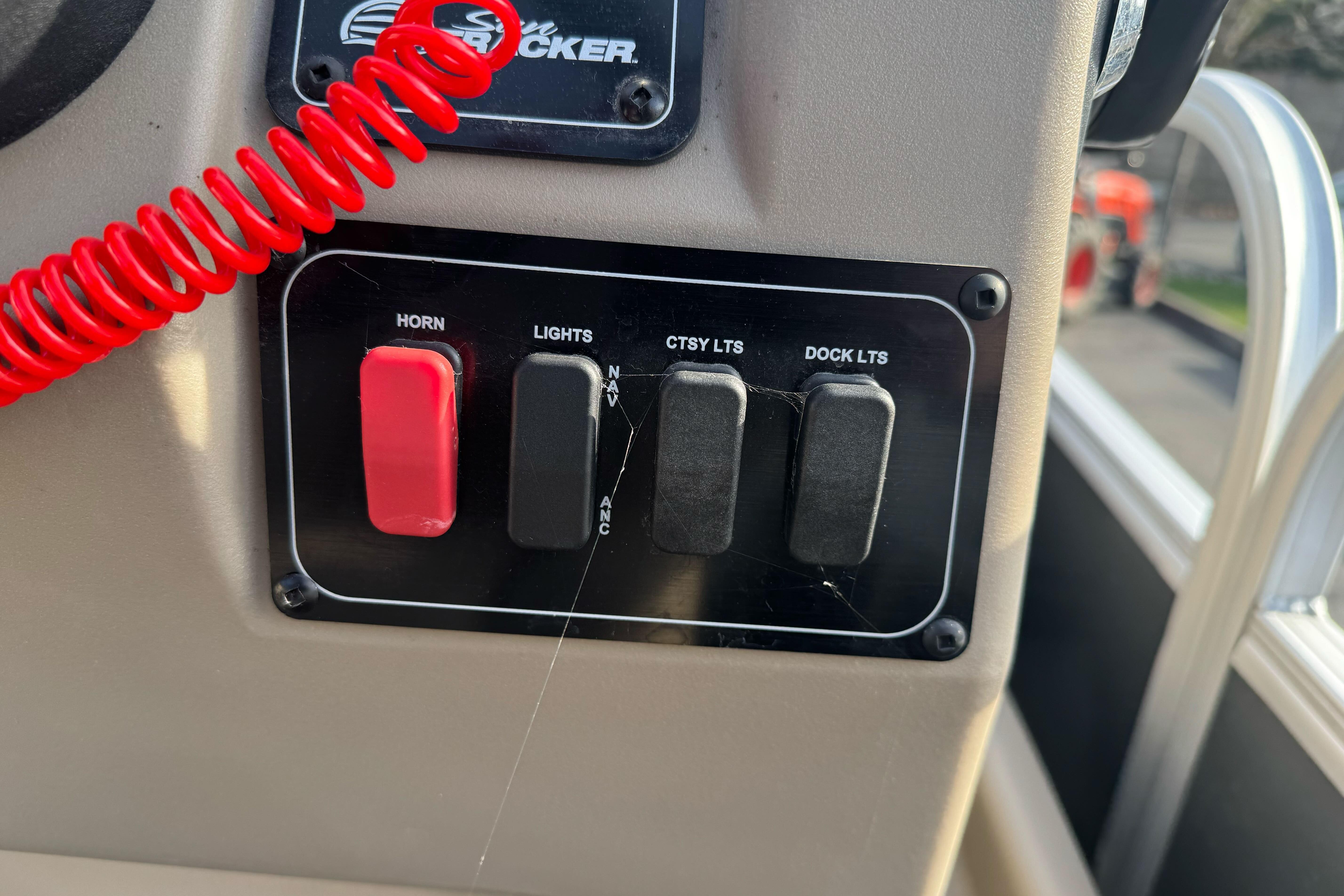 Control panel of 2024 Sun Tracker Party Barge 16 DLX with switches for horn and lights.