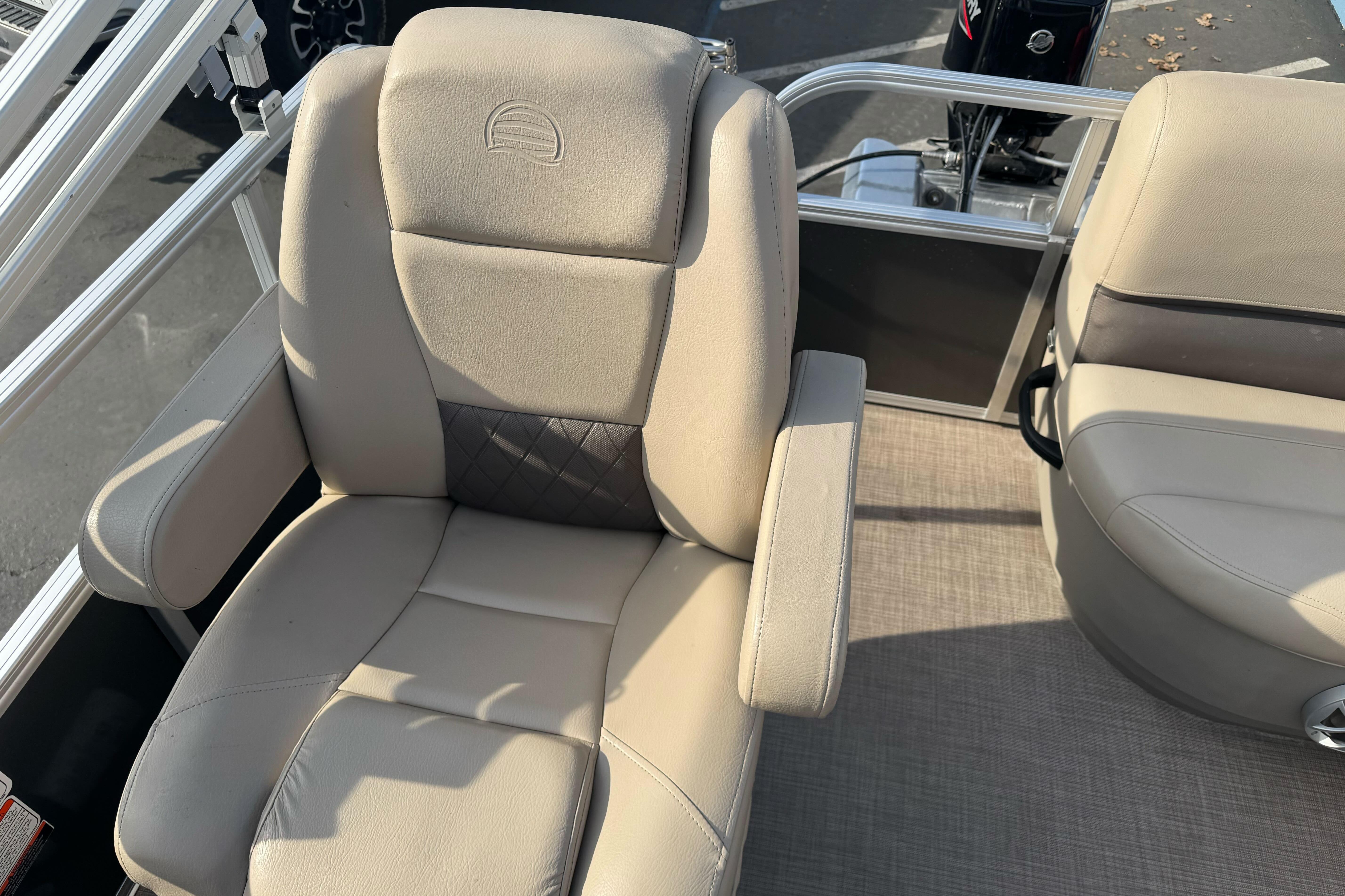 2024 Sun Tracker Party Barge 16 DLX boat seat with beige upholstery and armrests.