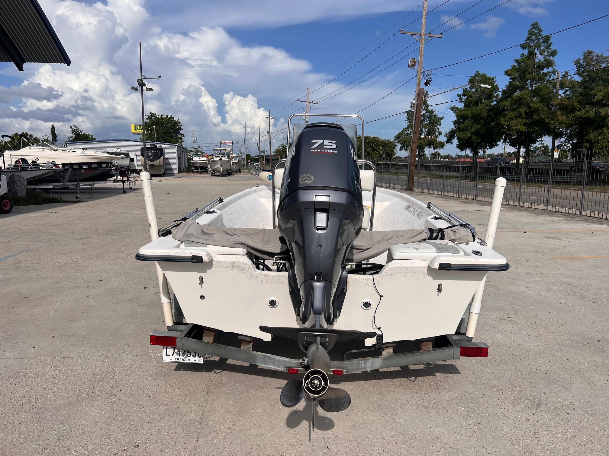 2010 Blue Wave 160 V Bay boat with 75 HP engine, parked outdoors under a cloudy sky.
