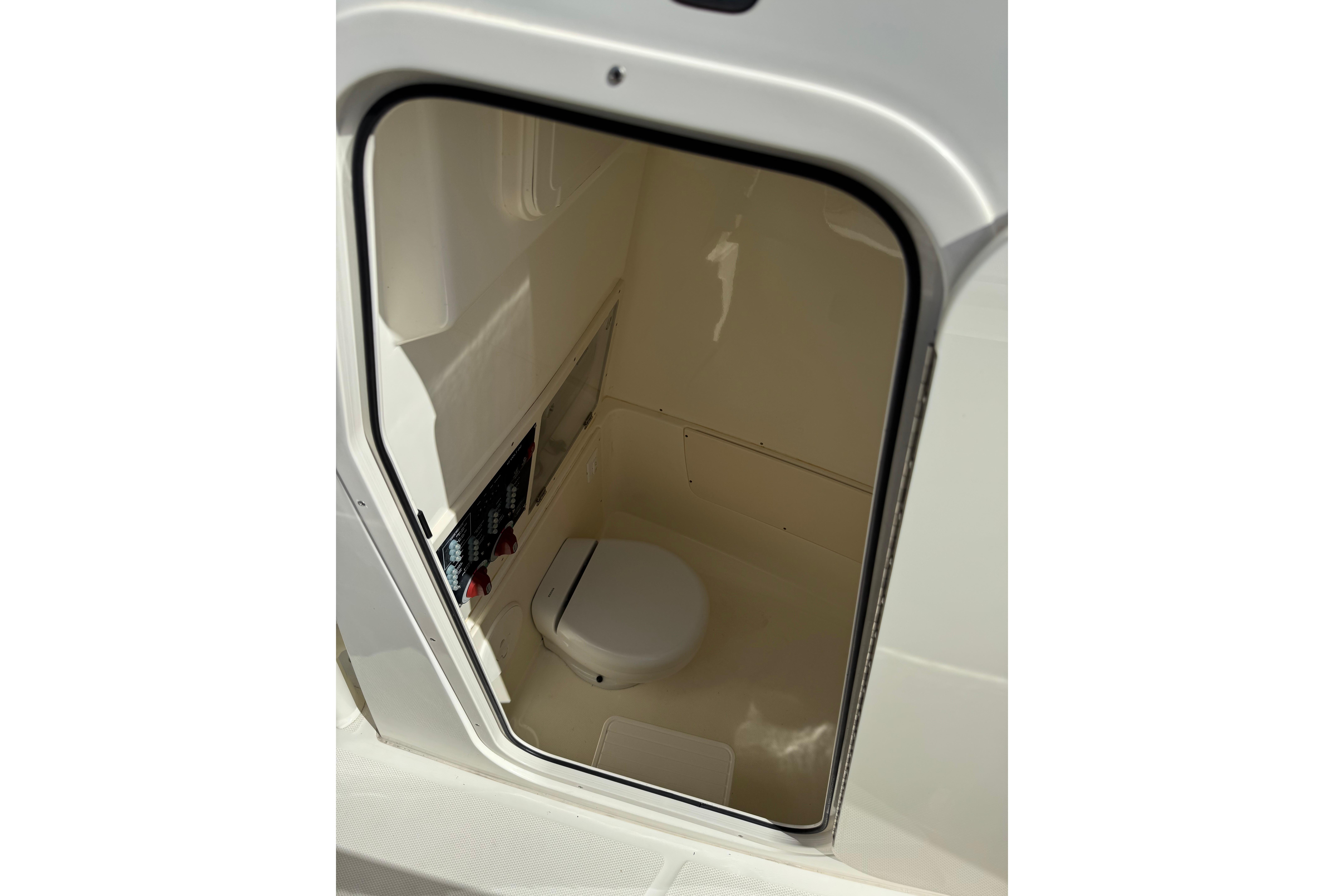 2020 Mako 235 boat interior cabin with compact toilet.