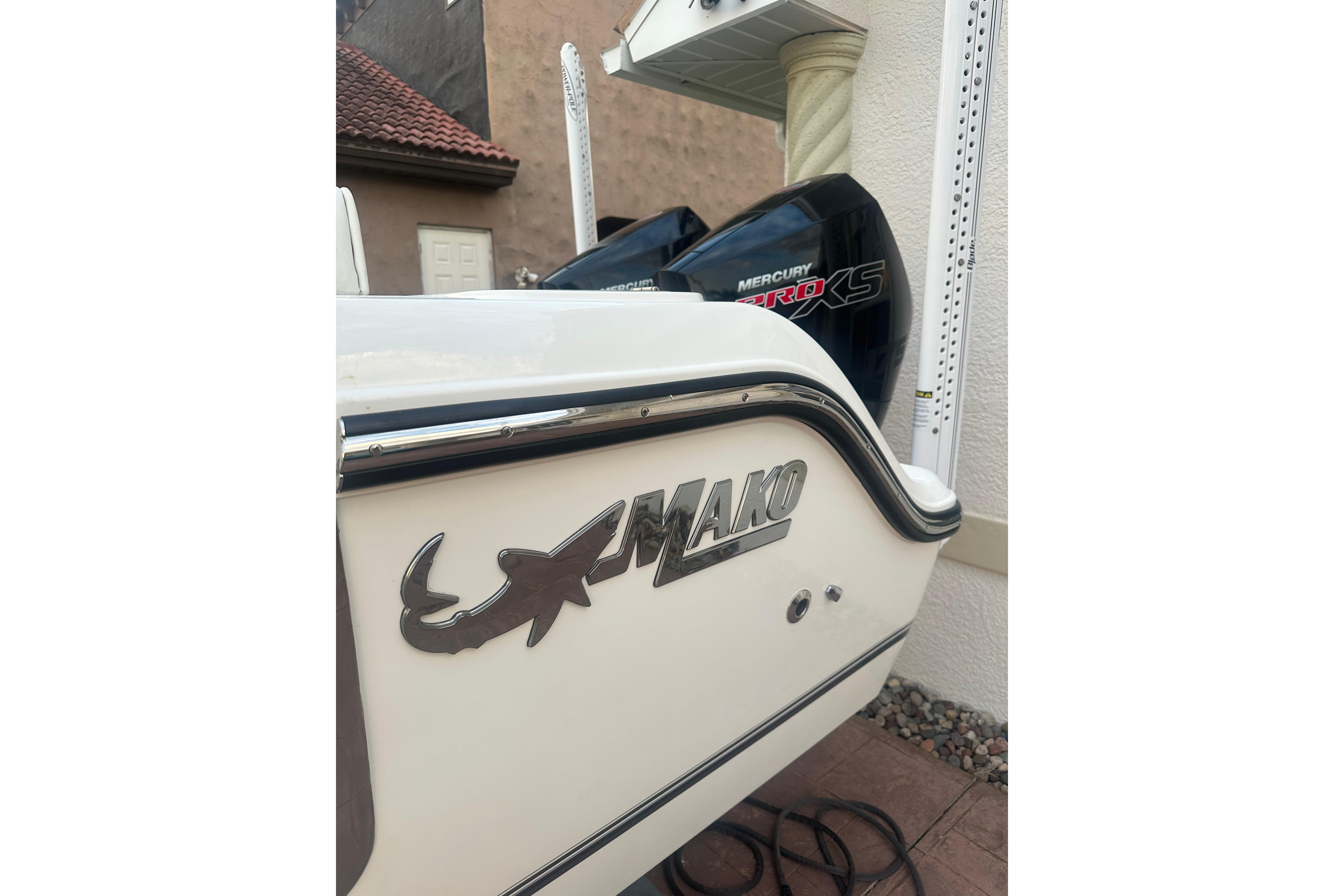2020 Mako 235 boat with Mercury Pro XS engine, parked near a building.