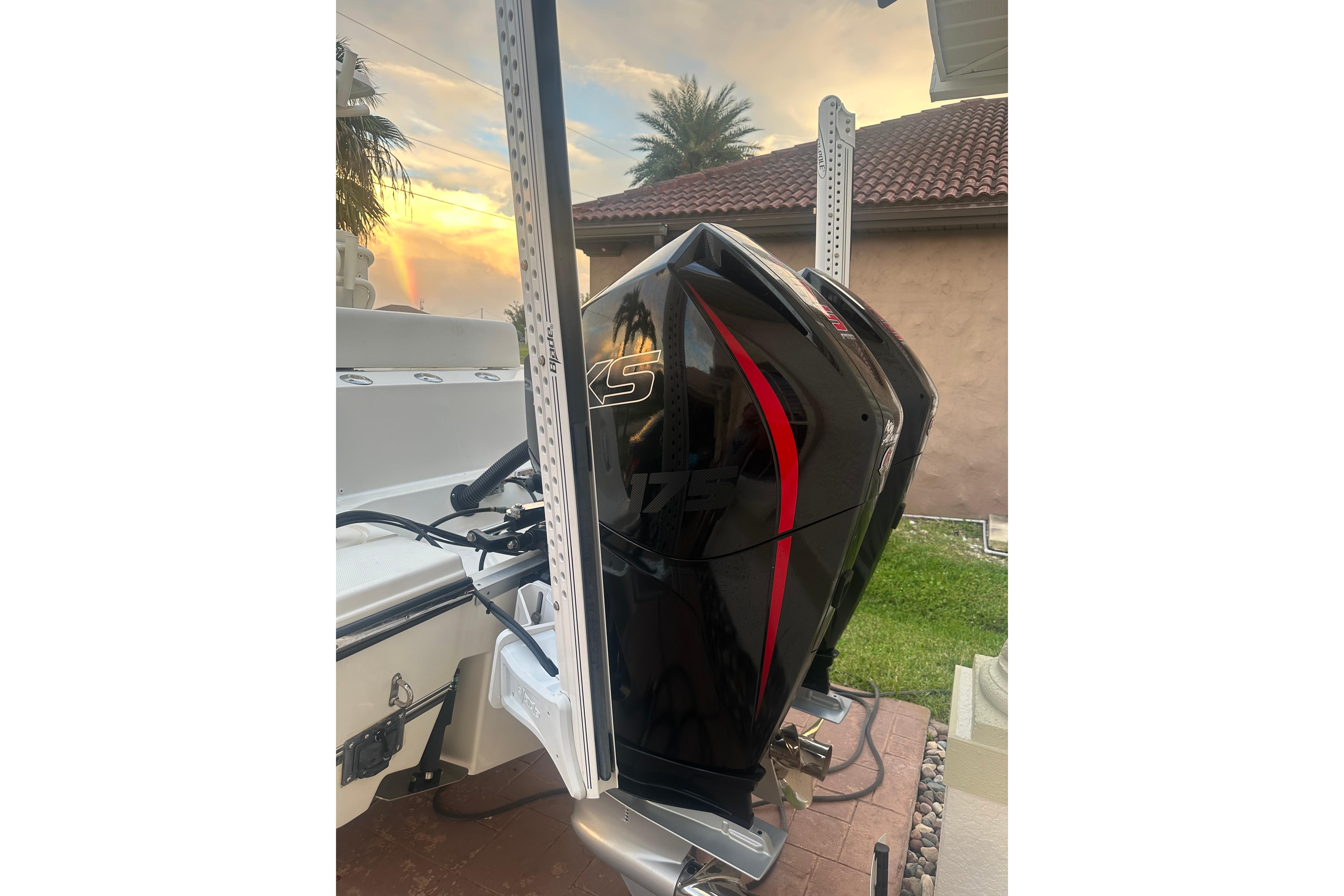 2020 Mako 235 boat with sleek black and red outboard motor at sunset.