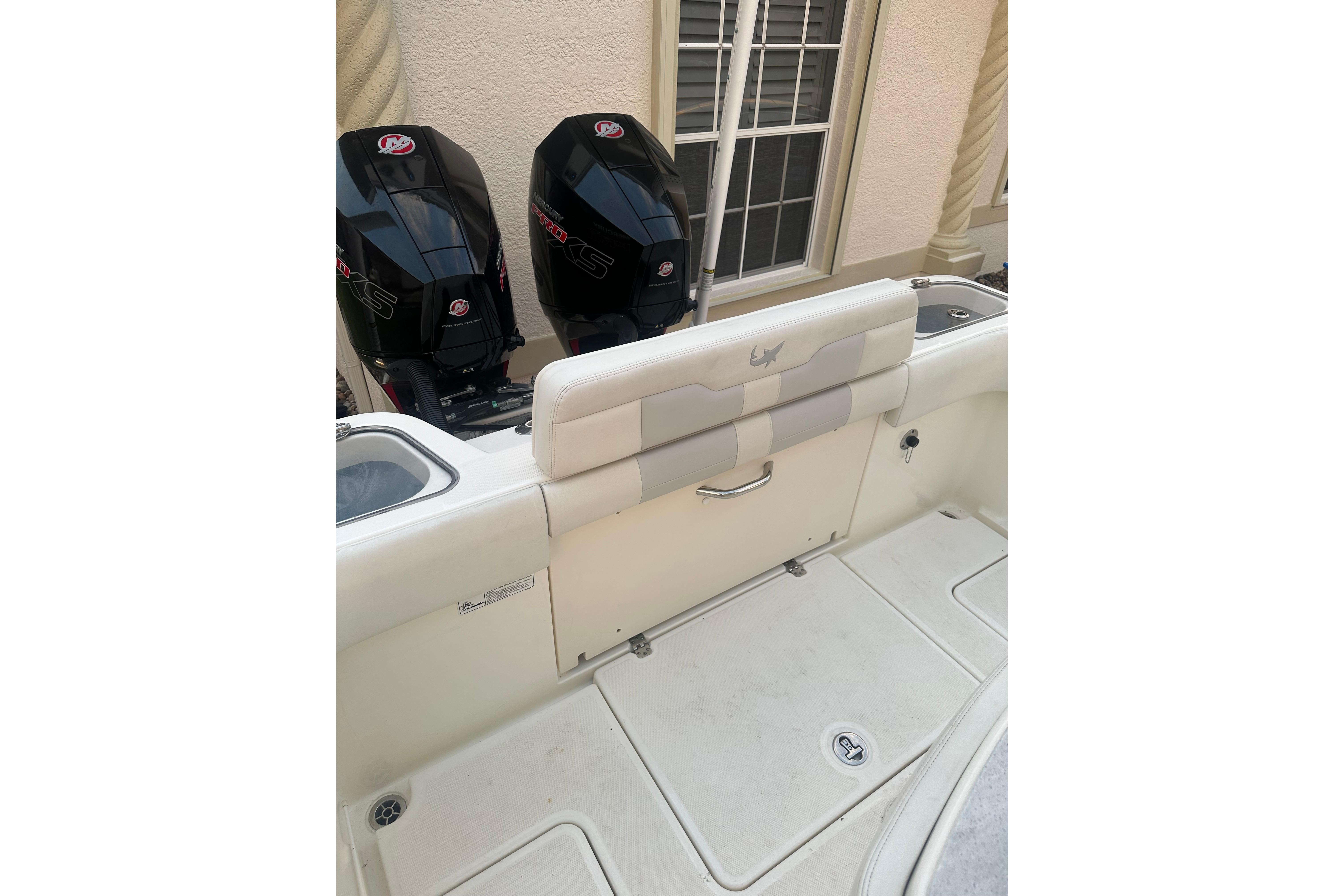 2020 Mako 235 boat with dual outboard engines and cushioned seating.