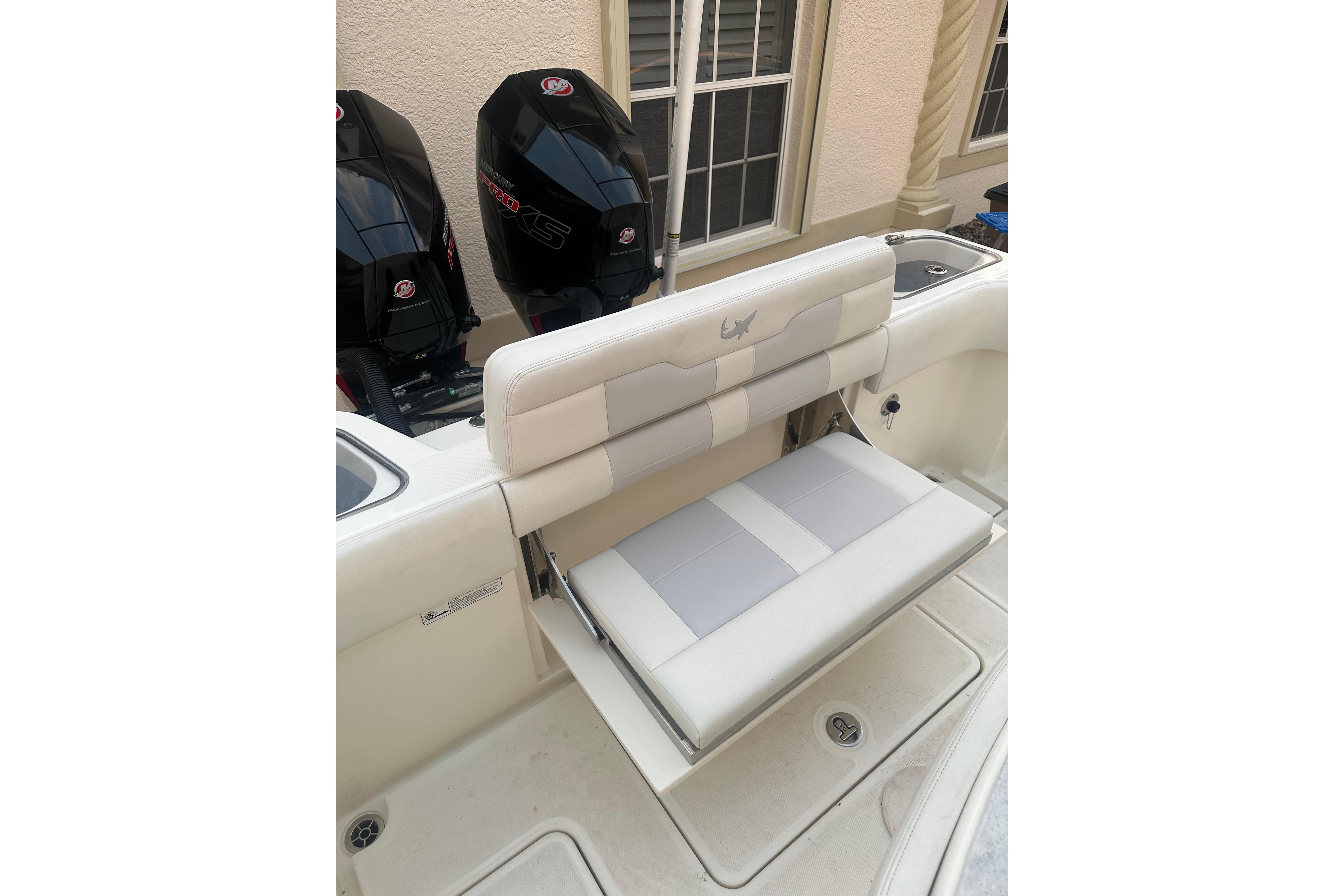 2020 Mako 235 boat with foldable seating and dual outboard engines.
