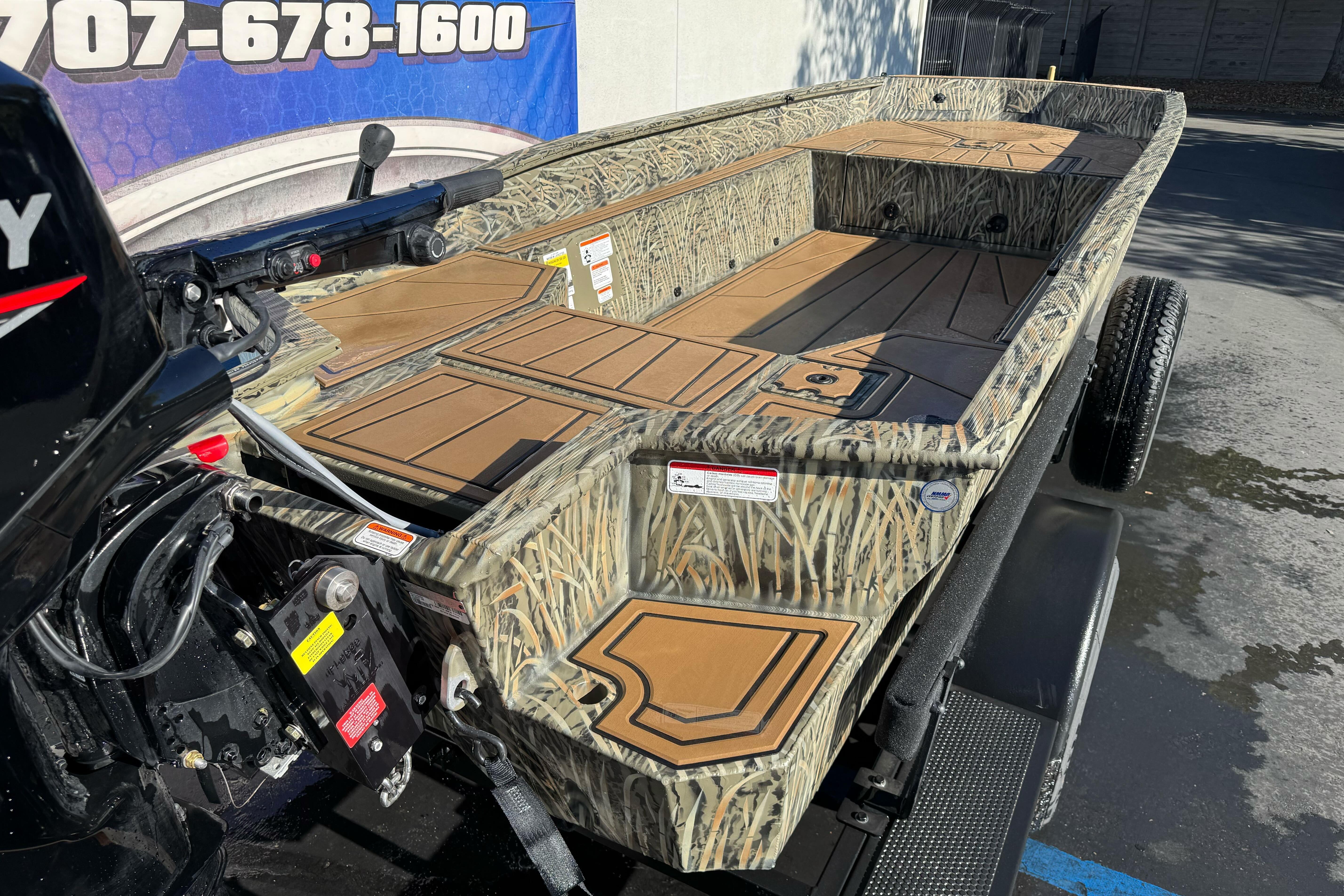 2026 Tracker Grizzly 1650 T Prairie Wings Edition boat with camouflage design on trailer.