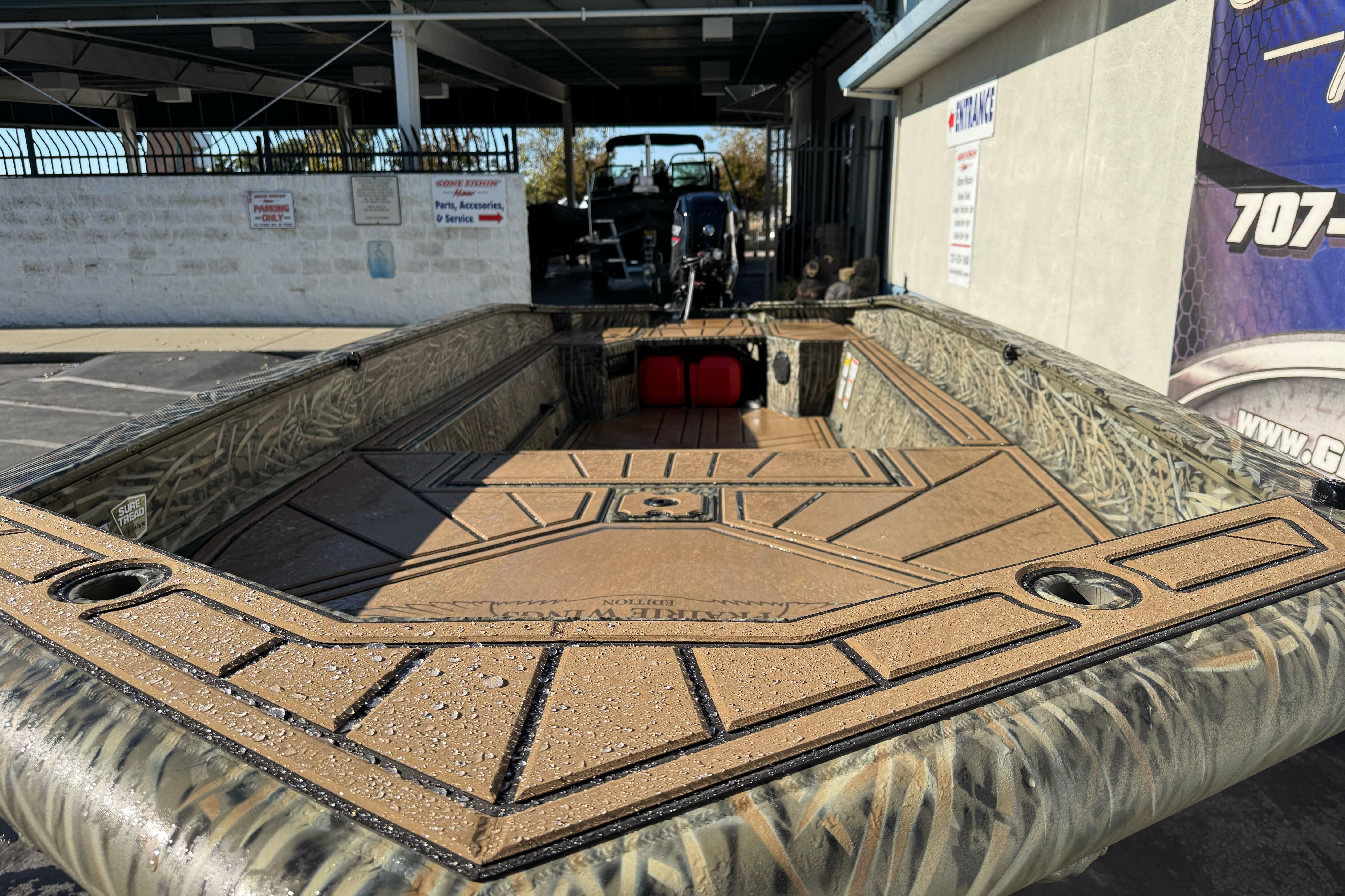 2026 Tracker Grizzly 1650 T Prairie Wings Edition boat with camo design in a showroom.