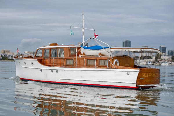 1939 Stephens Brothers Bridgedeck Cruiser on calm water, showcasing classic wooden design and elegant craftsmanship.