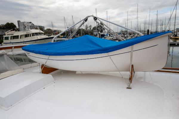 1939 Stephens Brothers Bridgedeck Cruiser with blue cover, docked in marina.