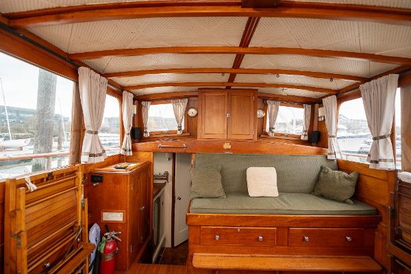Interior of 1939 Stephens Brothers Bridgedeck Cruiser with wooden furnishings and cozy seating.