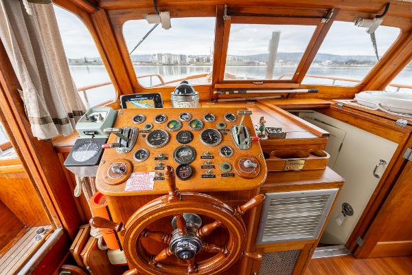 1939 Stephens Brothers Bridgedeck Cruiser helm with vintage wooden steering wheel and instrument panel.