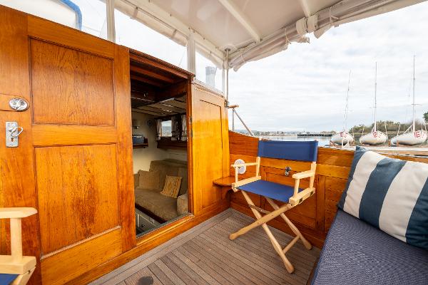 1939 Stephens Brothers Bridgedeck Cruiser interior with wooden paneling and seating.