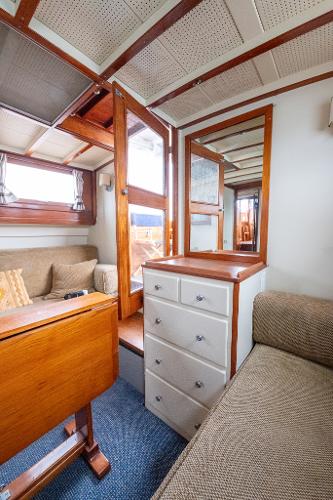 Interior of 1939 Stephens Brothers Bridgedeck Cruiser with wood accents and cozy seating.