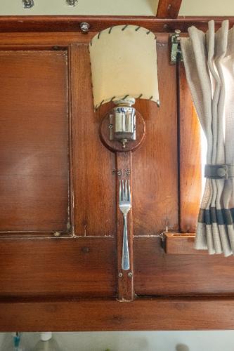 1939 Stephens Brothers Bridgedeck Cruiser interior with wooden paneling and vintage lamp.
