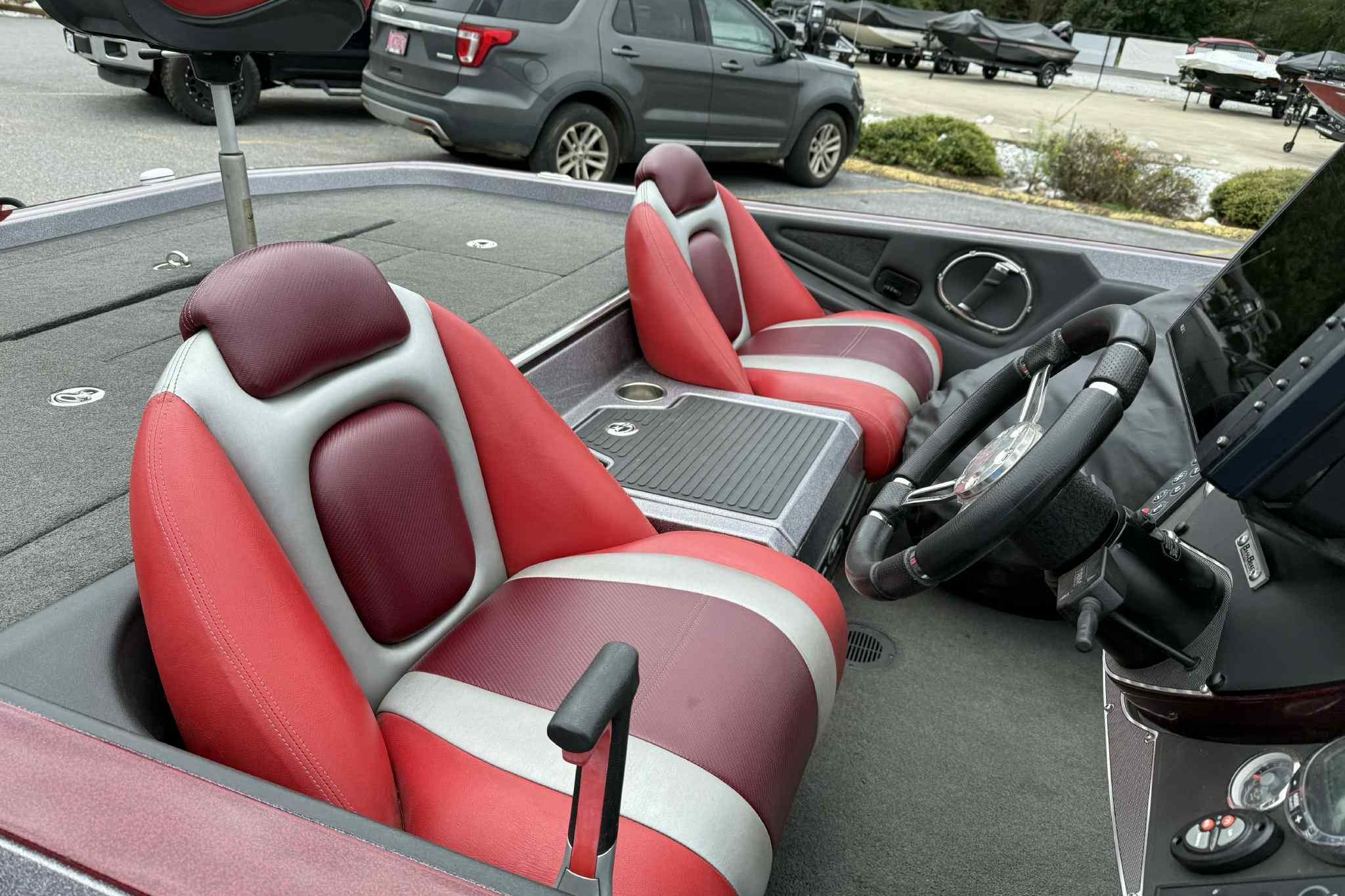 2014 Ranger Z521 Comanche boat interior with red and gray seats, steering wheel, and console.