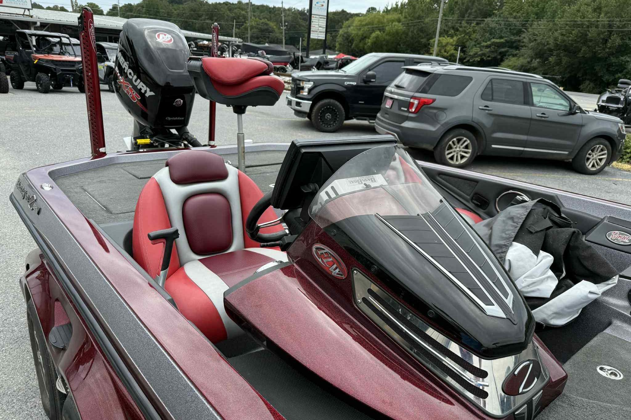 2014 Ranger Z521 Comanche boat with red and gray seating, parked outdoors.