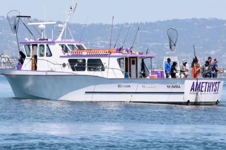 1978 Uniflite 50 boat "Amethyst" on water with people fishing, scenic background.