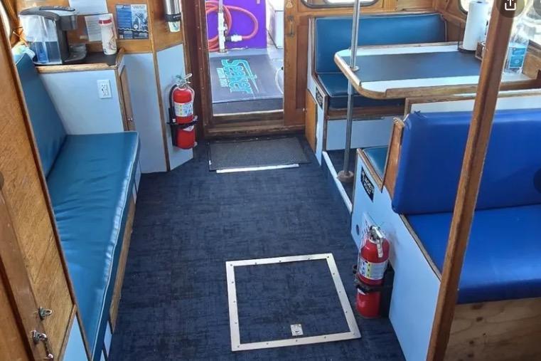 Interior of a 1978 Uniflite 50 boat with blue seating and fire extinguishers.