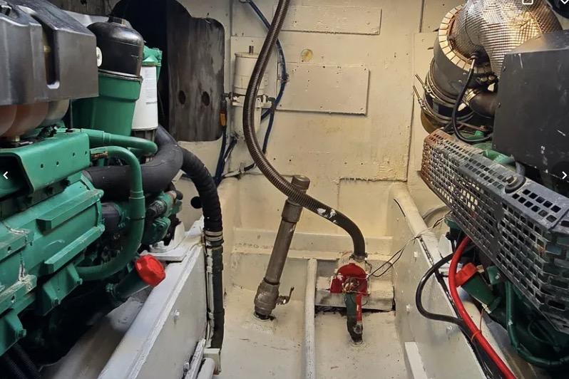 Engine room of a 1978 Uniflite 50 boat, featuring mechanical components and piping.