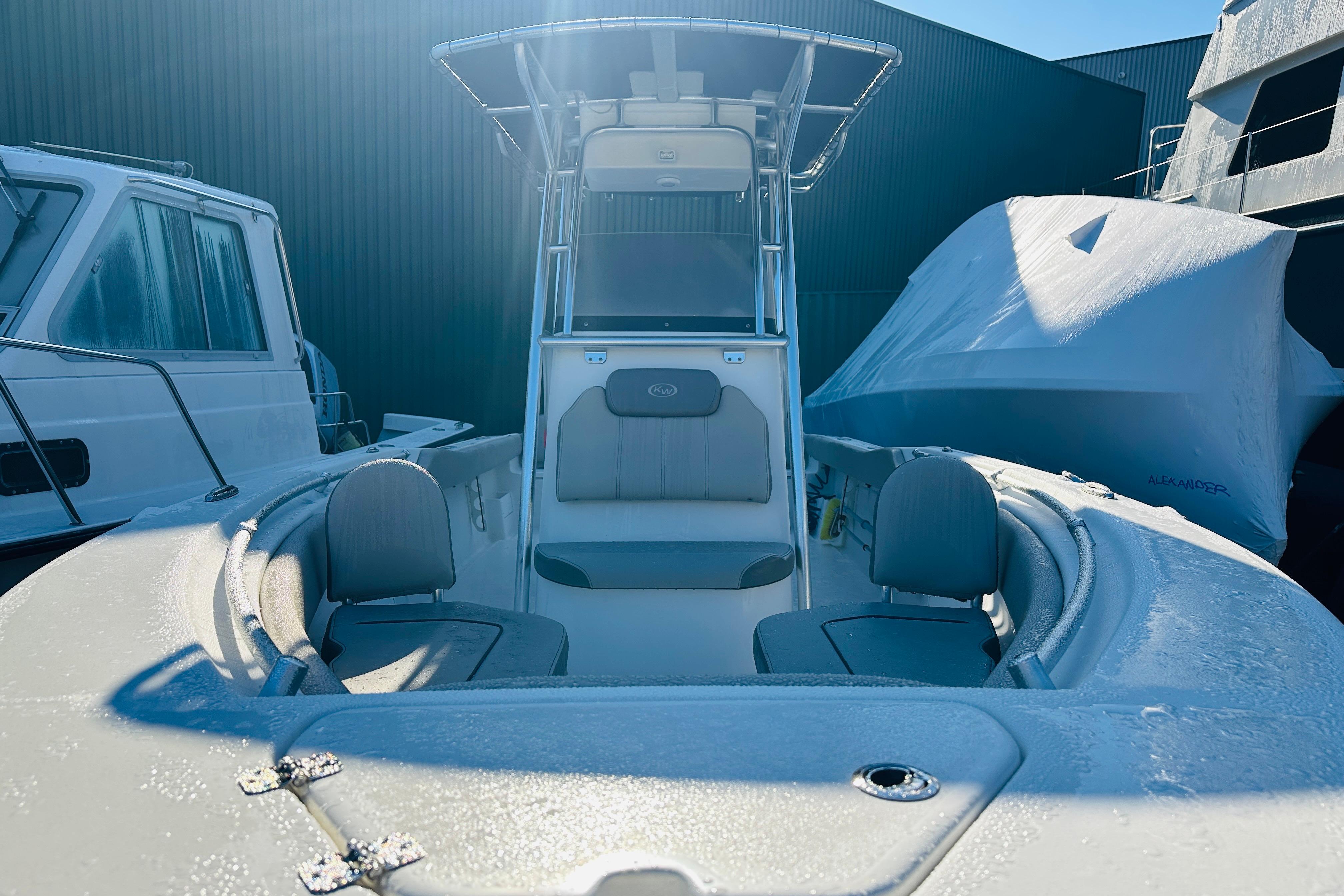 2022 Key West 239 FS boat with frosty deck, docked beside other vessels.