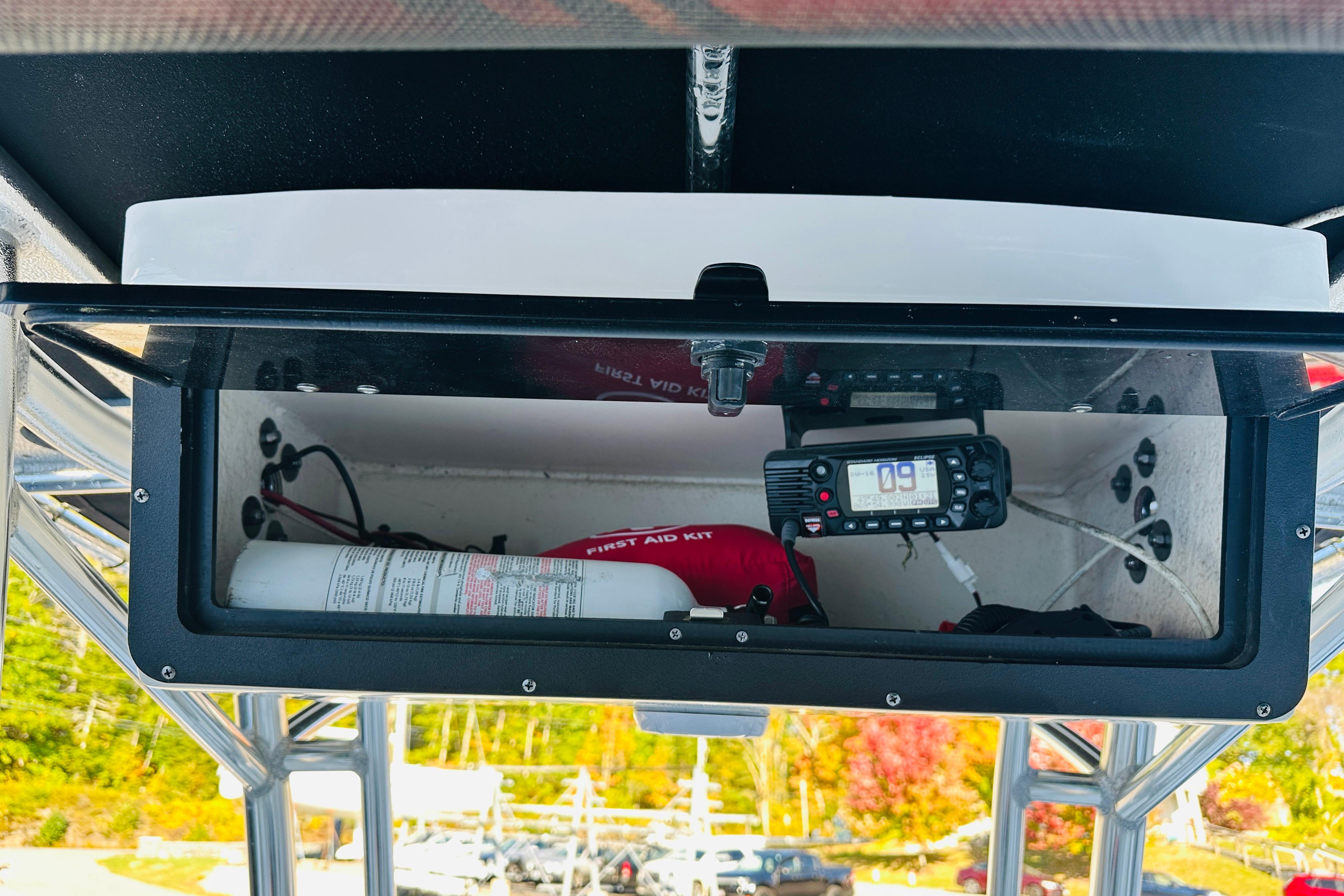 2022 Key West 239 FS boat storage compartment with first aid kit and radio equipment.