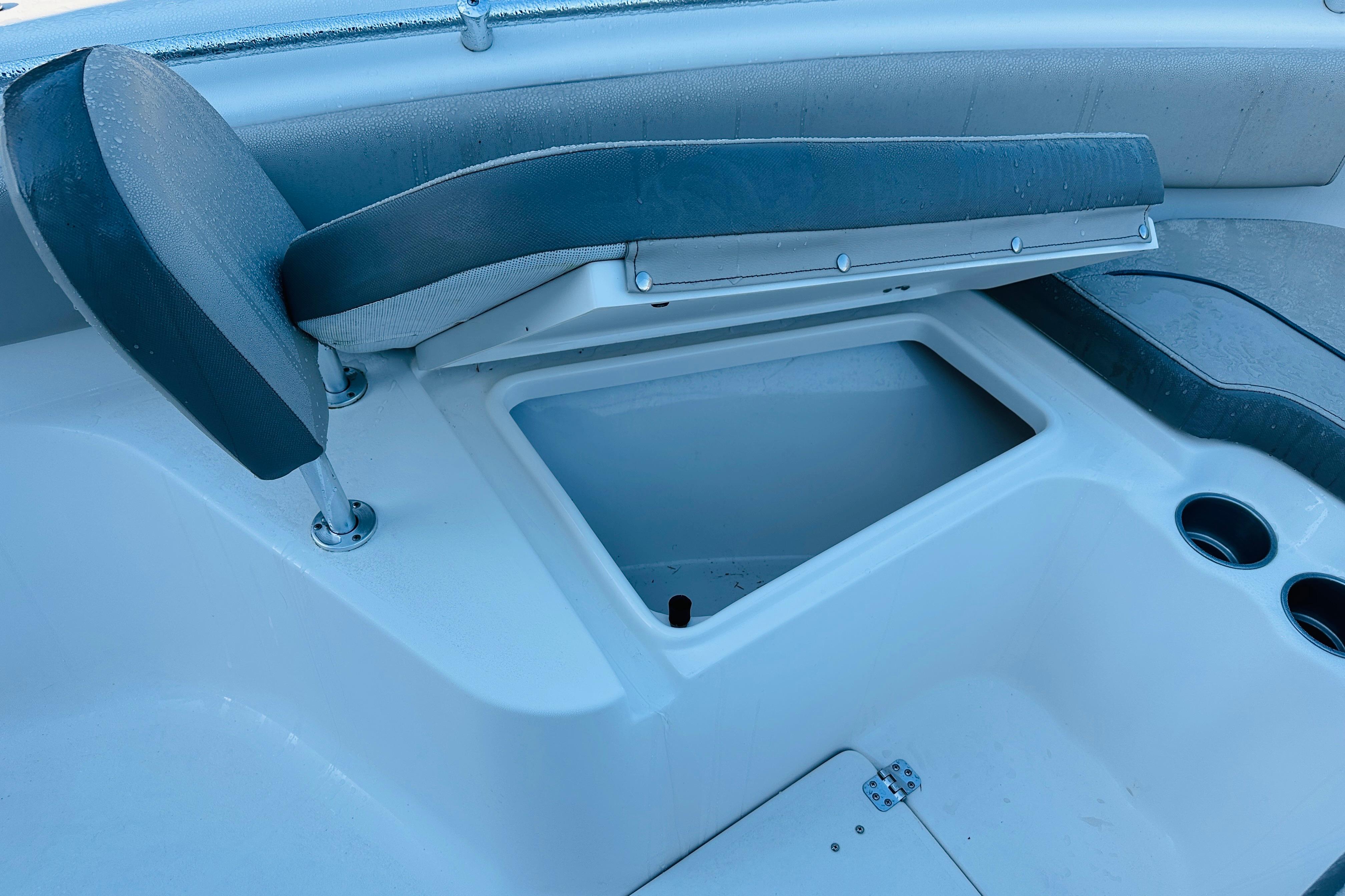 2022 Key West 239 FS boat seat with storage compartment and cup holders.