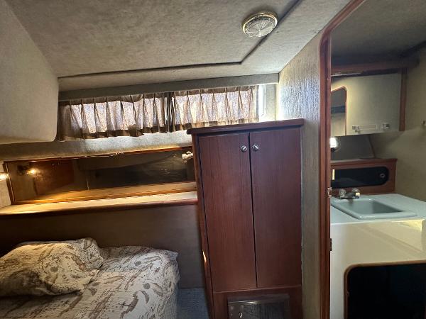 1987 Bayliner 3888 Motoryacht interior with bed, cabinet, and sink area.
