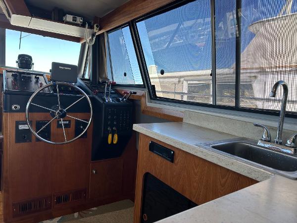 1987 Bayliner 3888 Motoryacht interior with steering wheel, control panel, and sink.