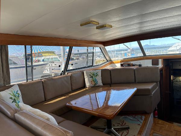 1987 Bayliner 3888 Motoryacht interior with spacious seating and wooden table, dockside view.