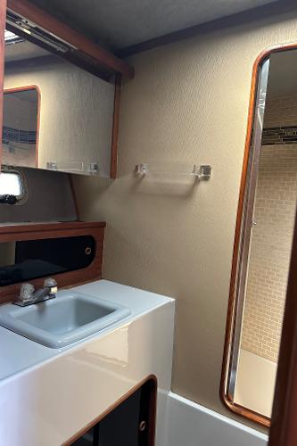 1987 Bayliner 3888 Motoryacht bathroom with sink, mirror, and wooden accents.