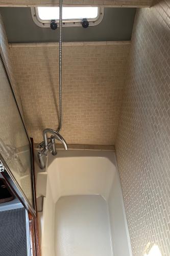 Shower area in 1987 Bayliner 3888 Motoryacht with tiled walls and window.