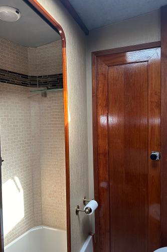1987 Bayliner 3888 Motoryacht bathroom with wood door and tiled shower.