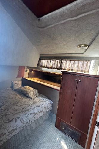 Interior cabin of 1987 Bayliner 3888 Motoryacht with bed and wooden cabinet.