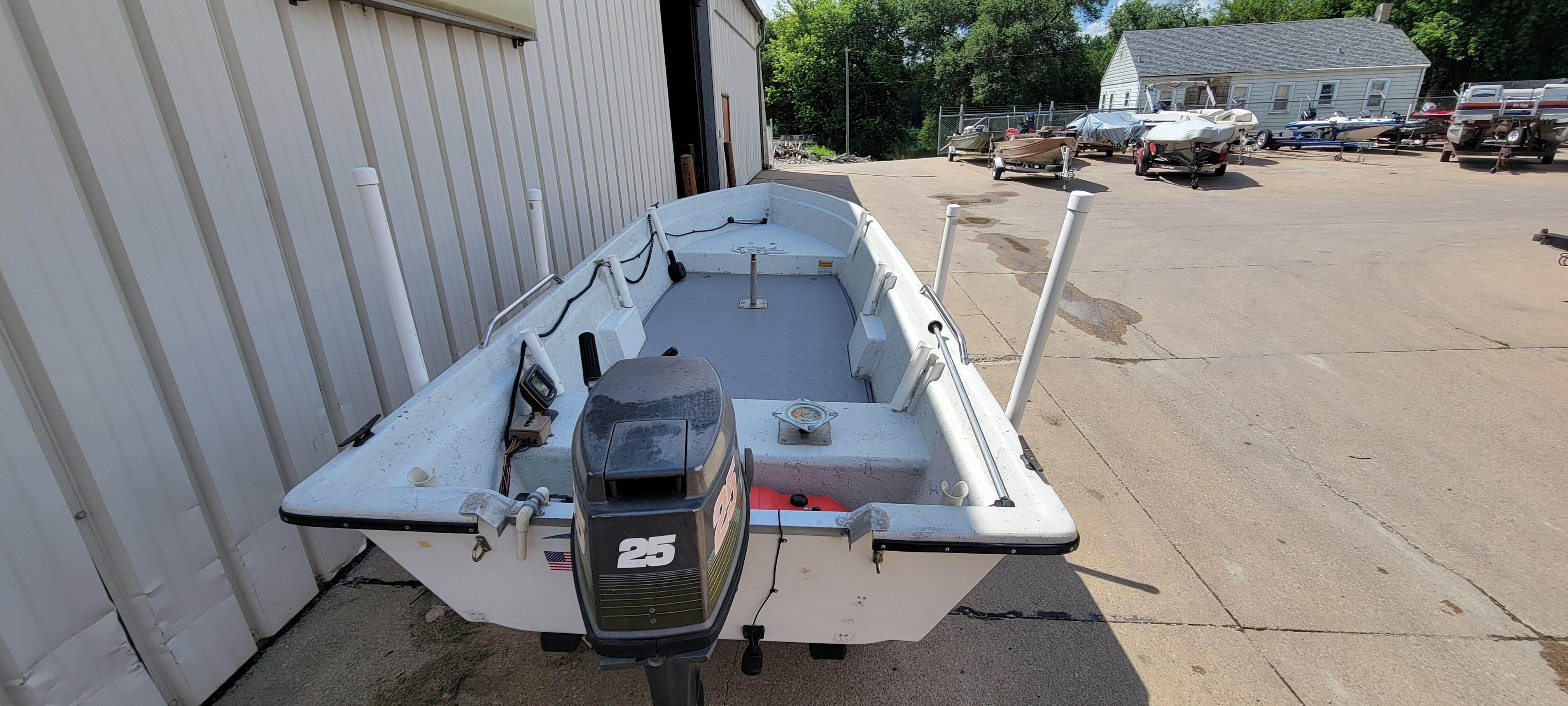 1996 Tracker Pro Angler V 16 boat with outboard motor in a boatyard.