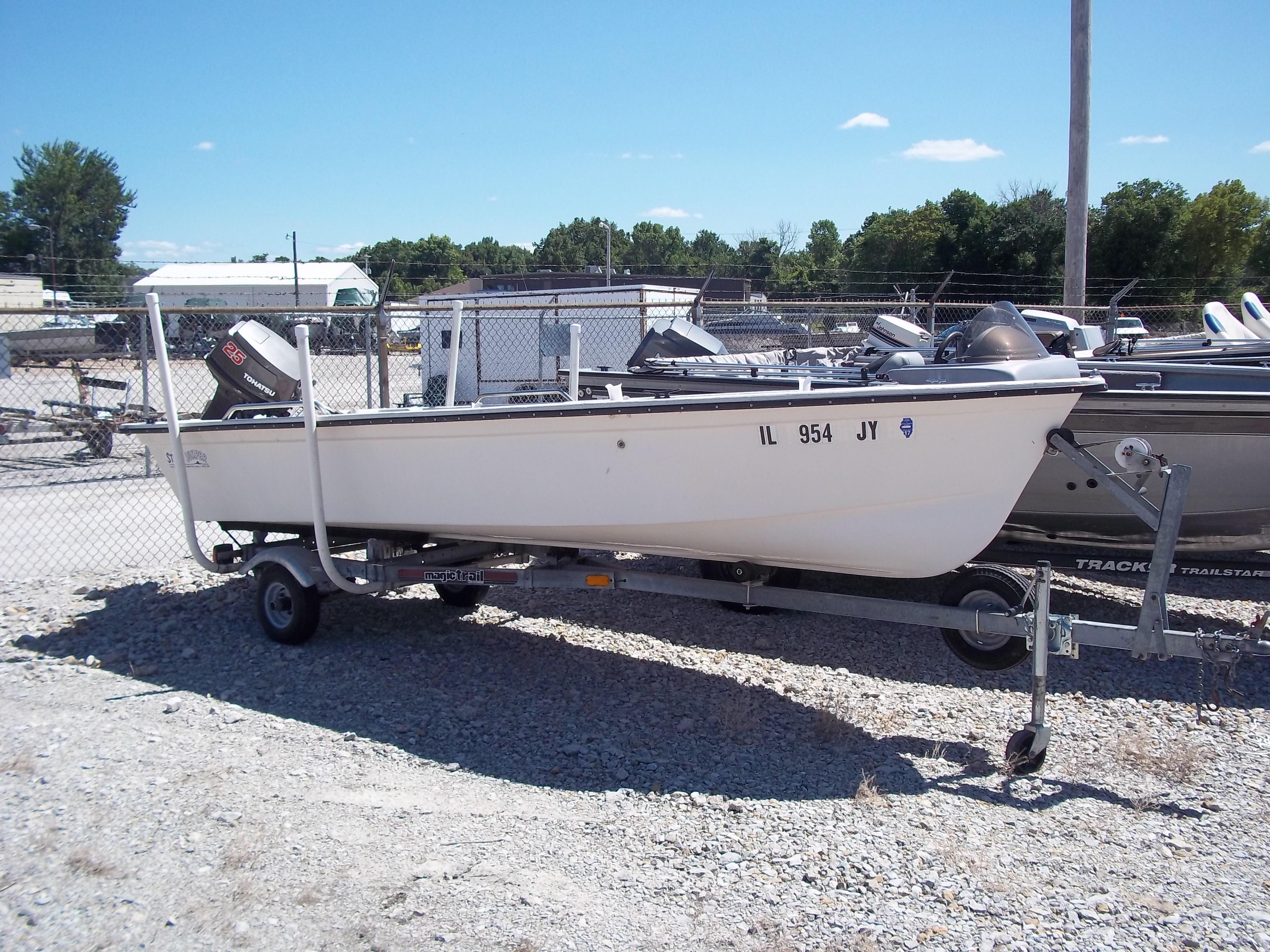1996 Tracker Pro Angler V 16 boat on trailer, parked outdoors.