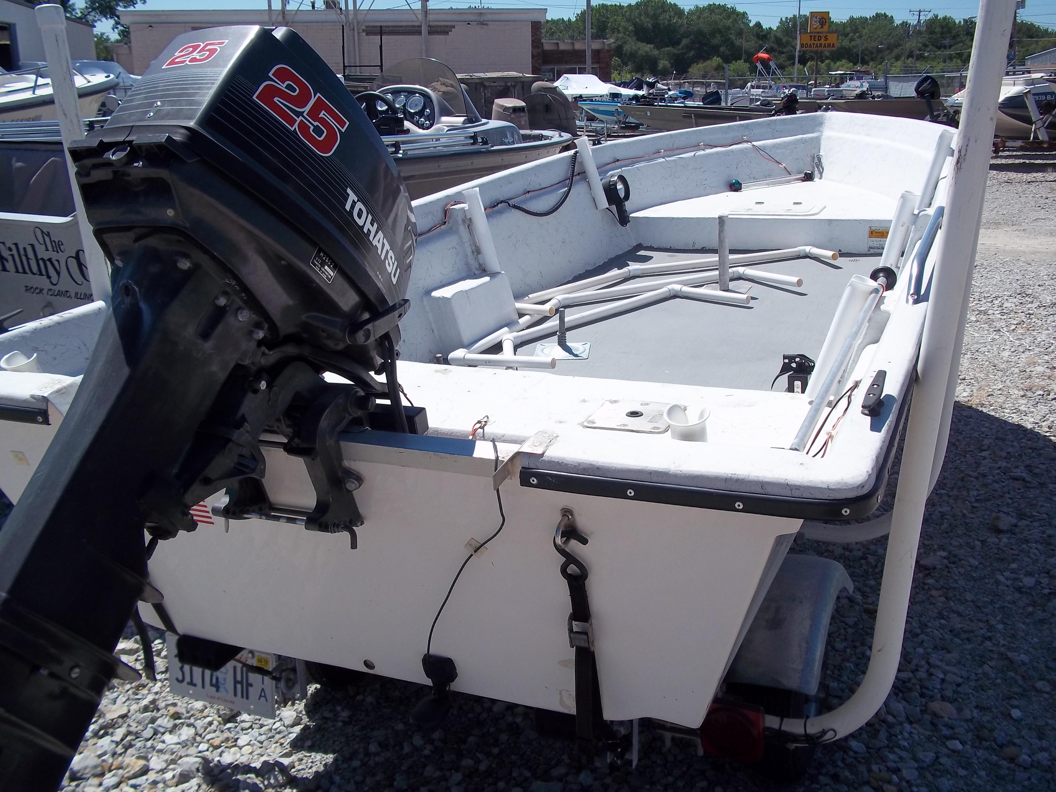 1996 Tracker Pro Angler V 16 boat with Tohatsu 25 outboard motor, parked on gravel.