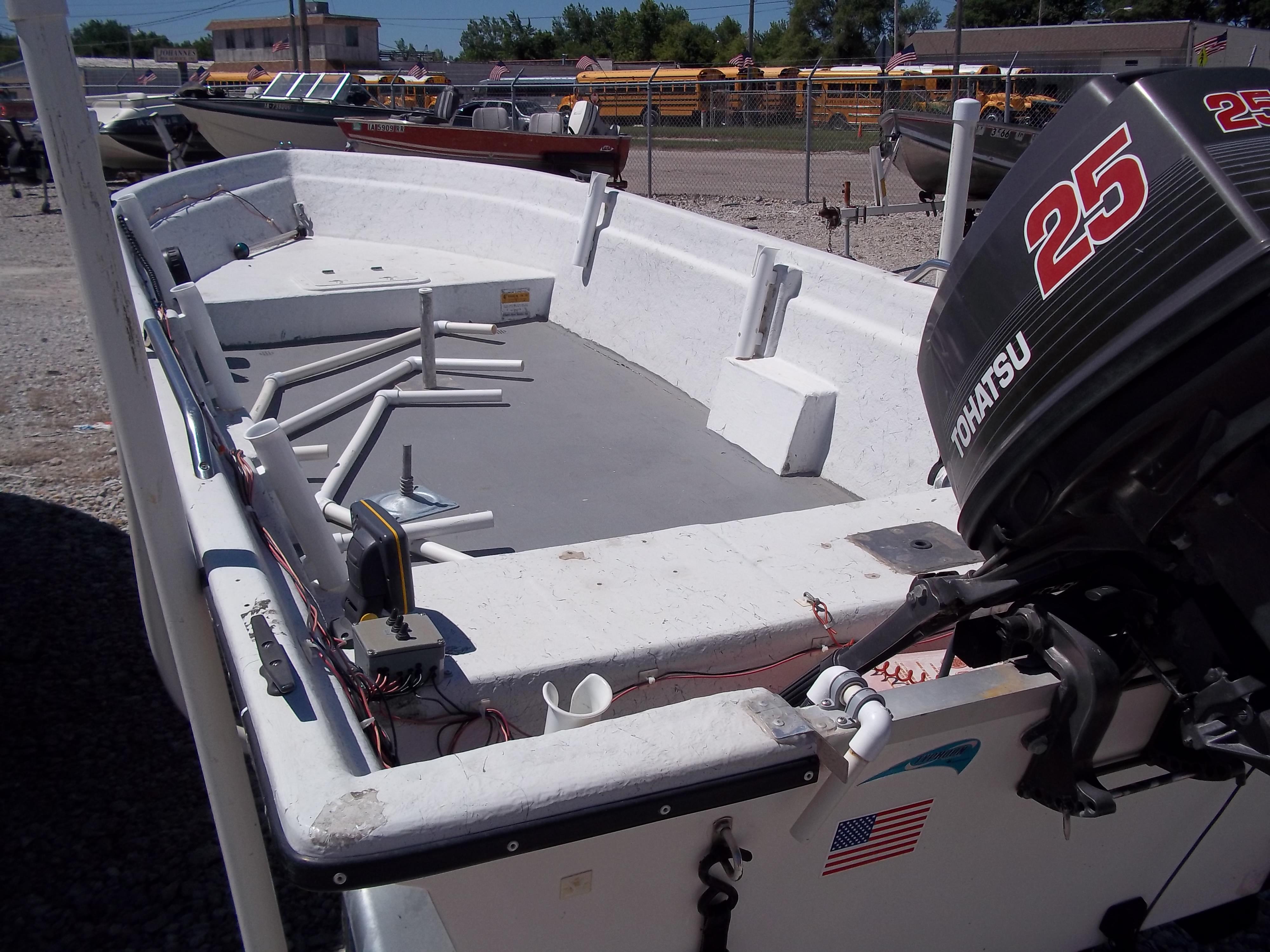 1996 Tracker Pro Angler V 16 boat with Tohatsu 25 outboard motor, parked outdoors.